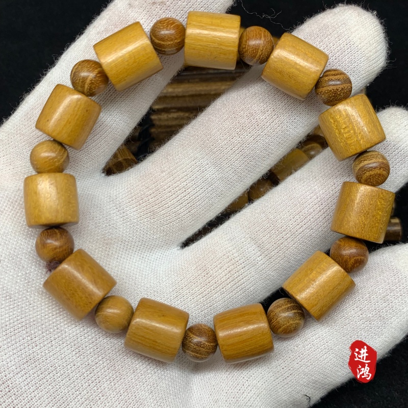 The new gold sandalwood bracelet in the bucket bead style is placed on a bamboo mat, presenting a simple and elegant look with its natural beauty fully displayed. Prayer beads 📿 cultural play bracelet prayer beads Item Picture
