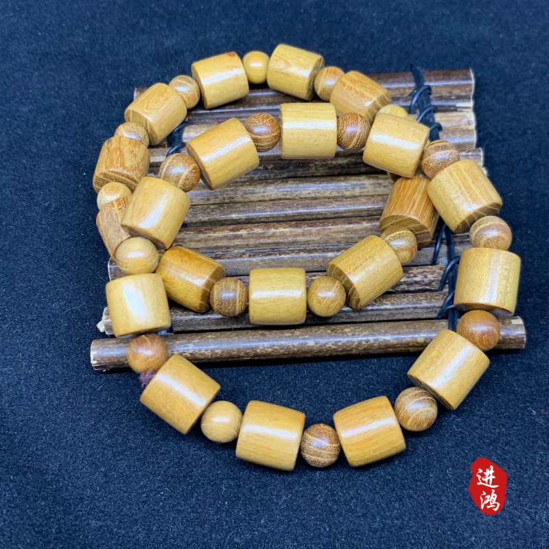 The new gold sandalwood bracelet in the bucket bead style is placed on a bamboo mat, presenting a simple and elegant look with its natural beauty fully displayed. Prayer beads 📿 cultural play bracelet prayer beads details Picture
