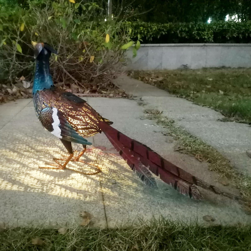 Outdoor solar lamps decorate the garden courtyard with animal statues and ironwork paintings of birds and pheasants for export from the UK and the US full figure