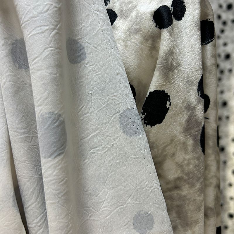 This fabric features a soft and drape design with a stir-fried grey base, slightly wrinkled satin finish, and irregular large polka dot printed acetate fabric details Picture