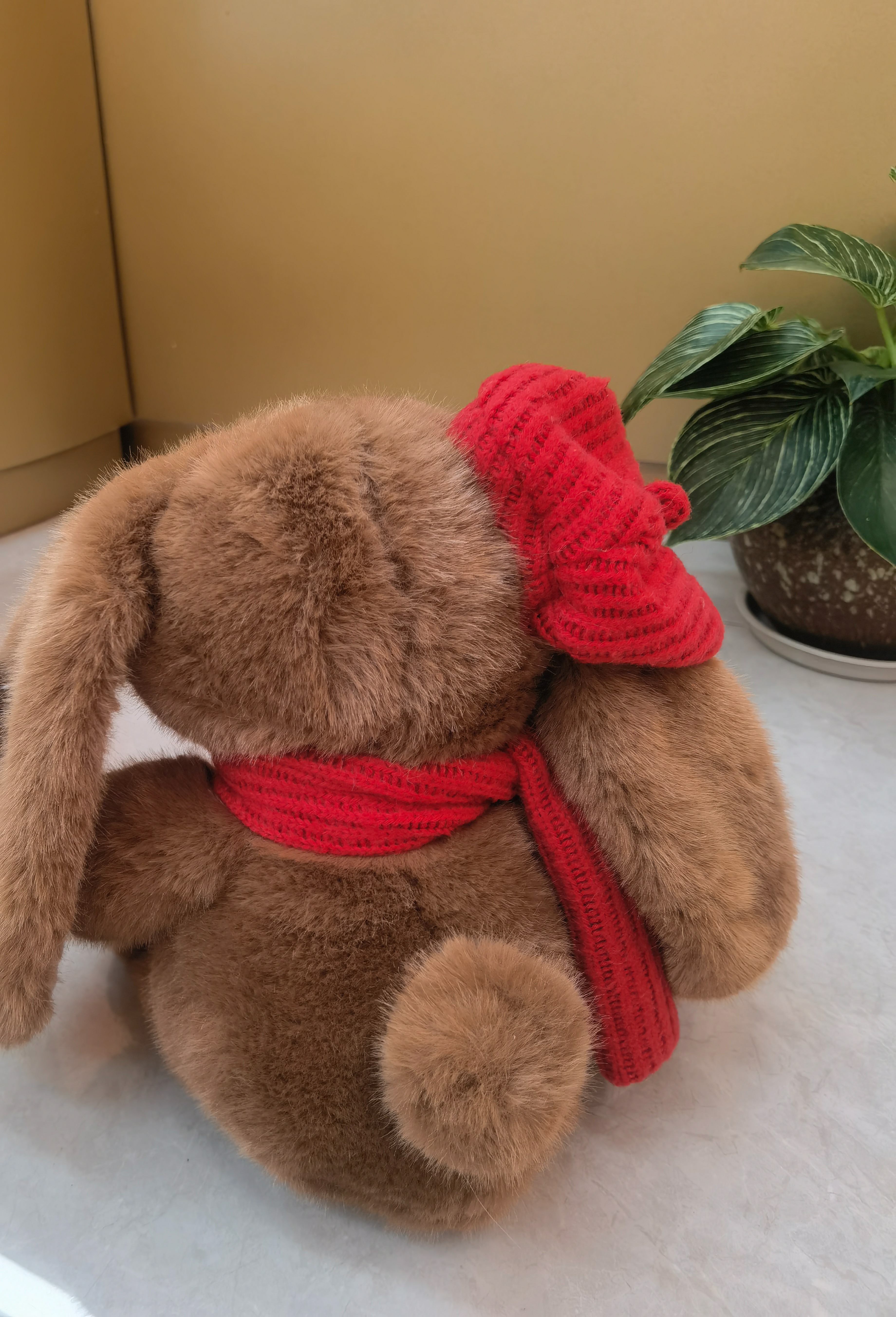 A 35CM cute rabbit wearing a red scarf and accompanied by green plants, warm and adorable. Specification image