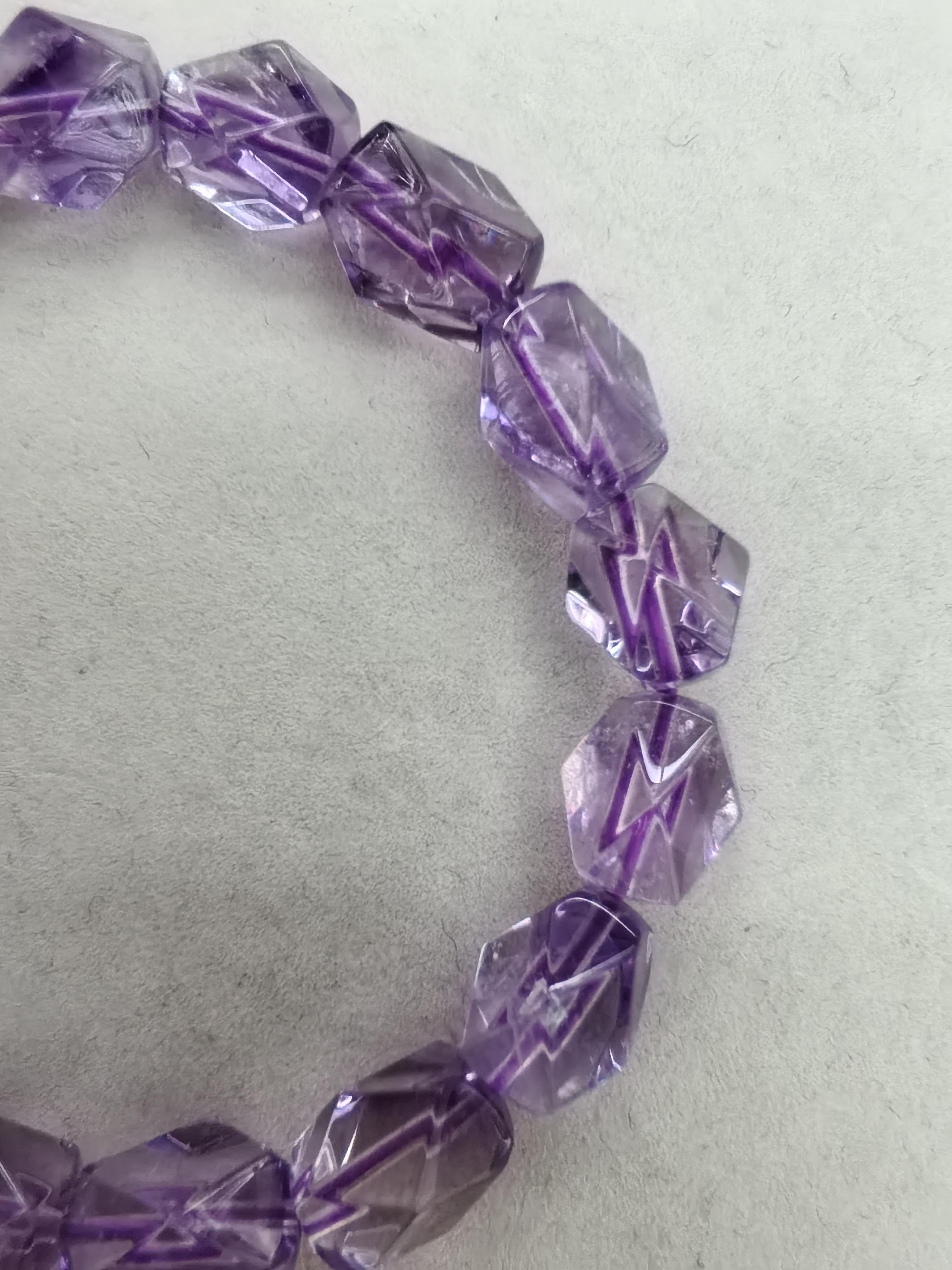 紫水晶（Amethyst）紫绒发
宛如晨曦凝结的霞光，通体萦绕着从淡雅丁香到深邃皇家紫的梦幻色泽，其紫色因含微量铁离子细节图