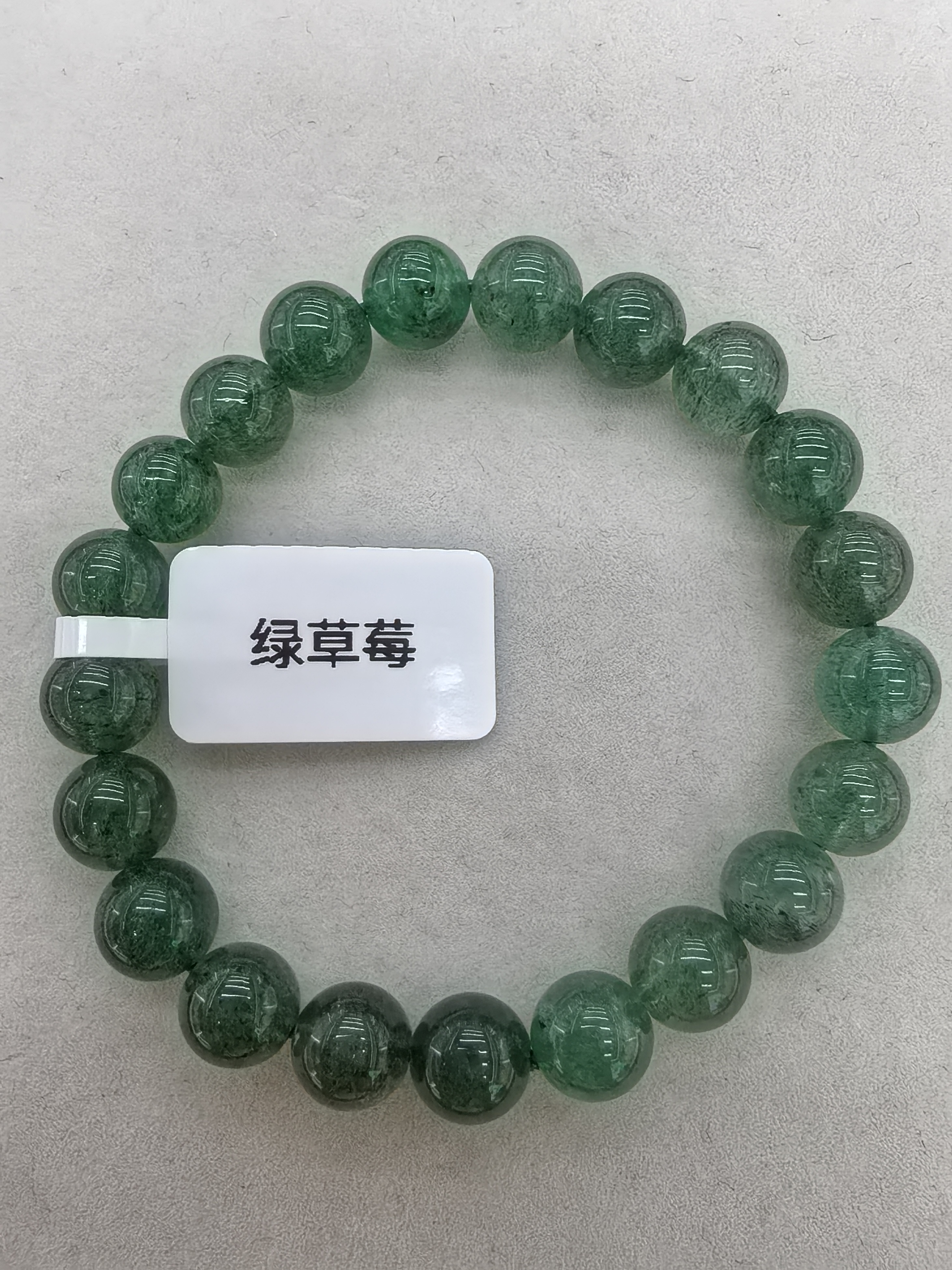 水晶界的“绿莓蜜冻”，自带软甜治愈力的绿草莓晶！清透浅绿底里嵌满圆润如“草莓籽”的包裹体，转动时像捧着颗颗鲜活绿莓