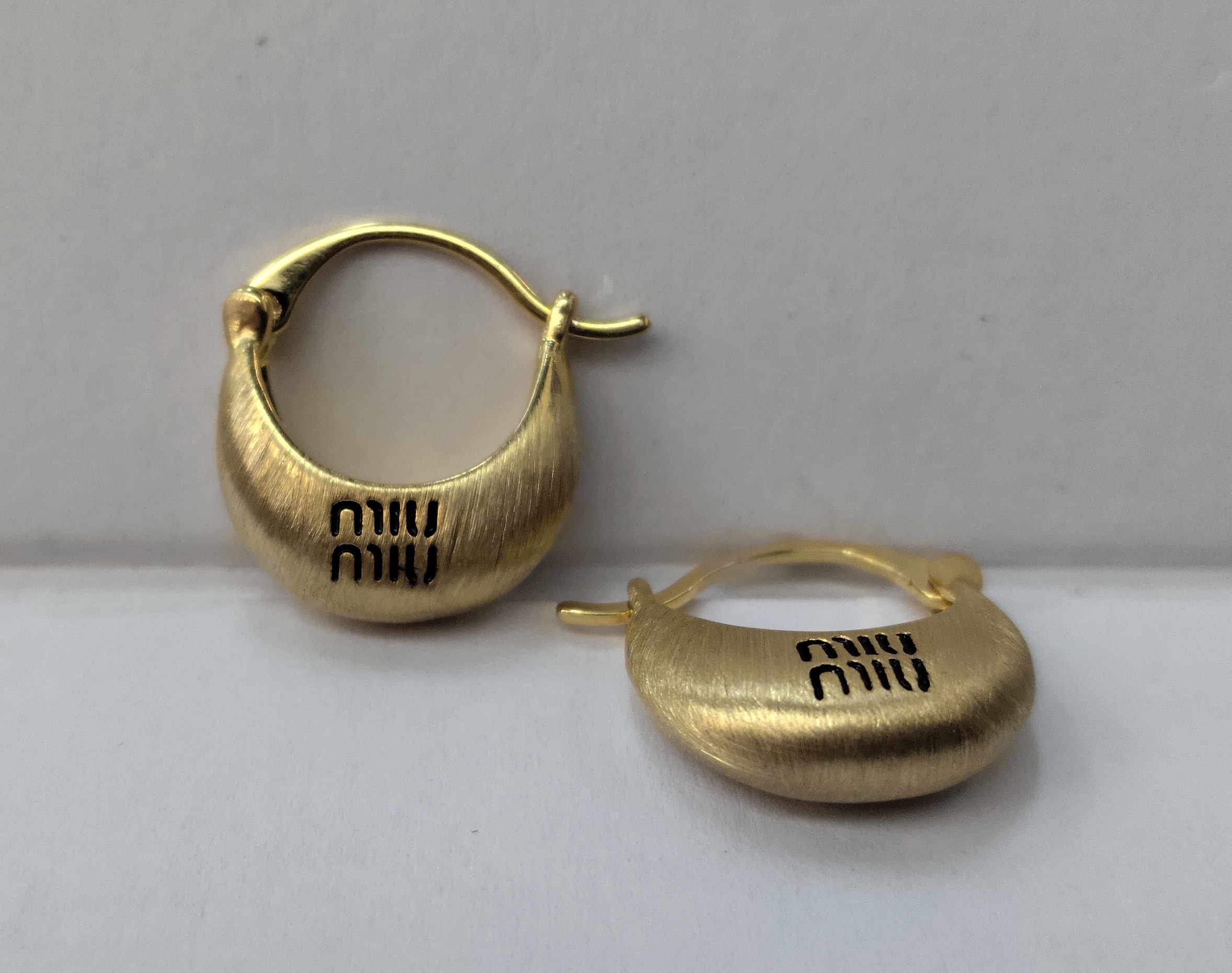 The new Waka Mi golden ear buckles are engraved with the English words "MIUMIU", and their simple design exudes a unique charm Item Picture