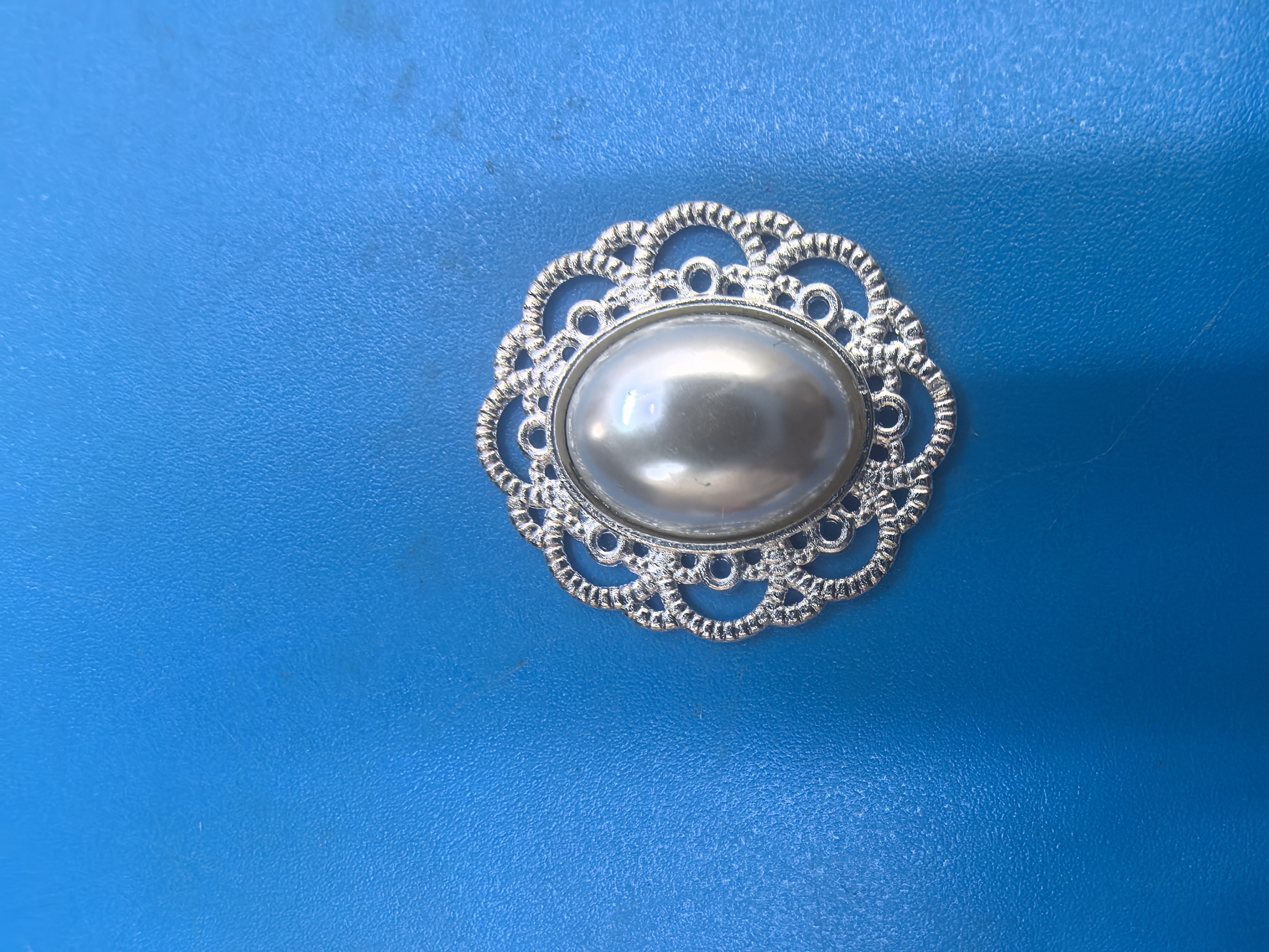 本产品1合金做底盘；2、3铁片底盘，上面由高光半面珍珠镶嵌而成，可用做胸花点缀，饰品、鞋扣装饰等等；做工精细外观简大方。