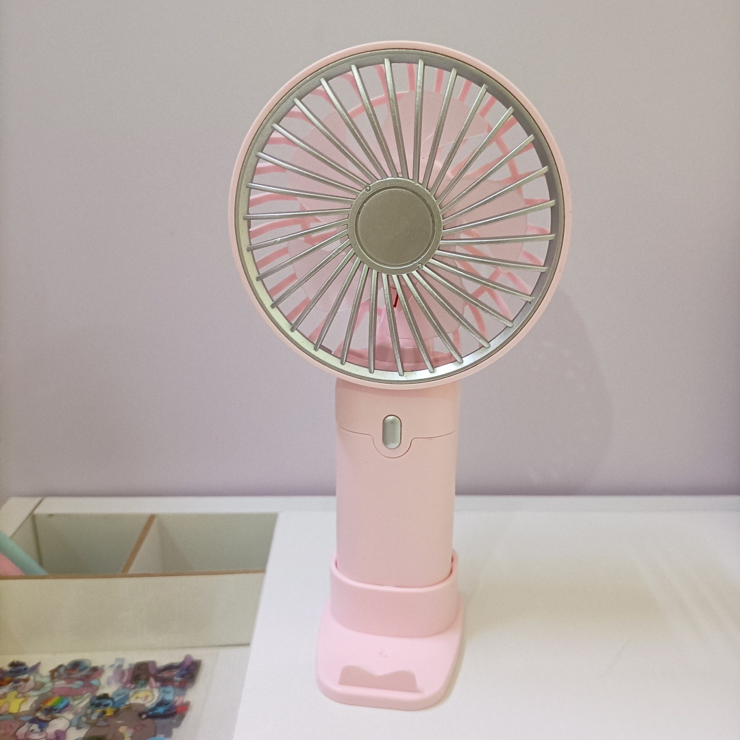 The new simple and mini handheld fan has a strong wind force and can be charged by USB. It is a portable desktop stand for outdoor students Application Scenario