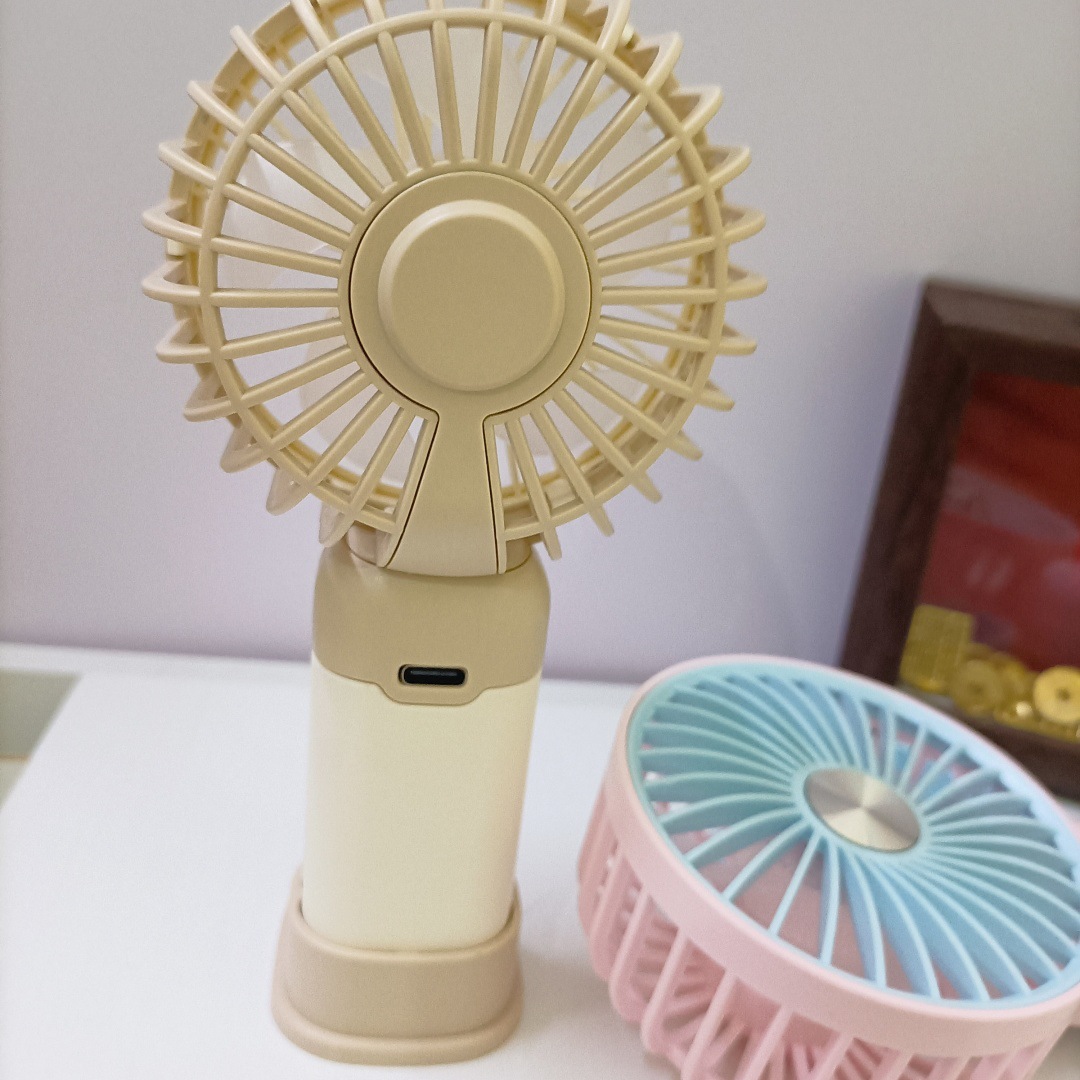 The new simple and mini handheld fan has a strong wind force and can be charged by USB. It is a portable desktop stand for outdoor students Application Scenario