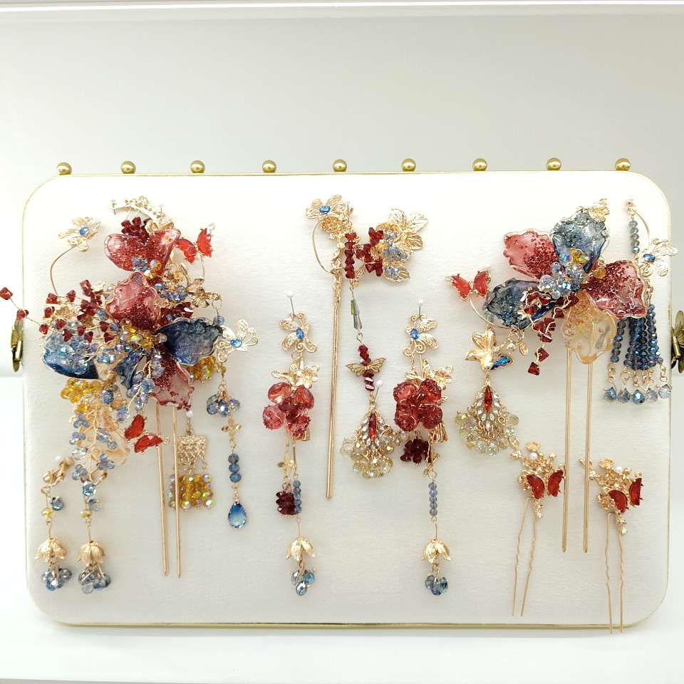 A nine-piece set of Chinese-style jewelry with red crystal charm, blue diamond flowing light, and golden branches adorned with blooming flowers