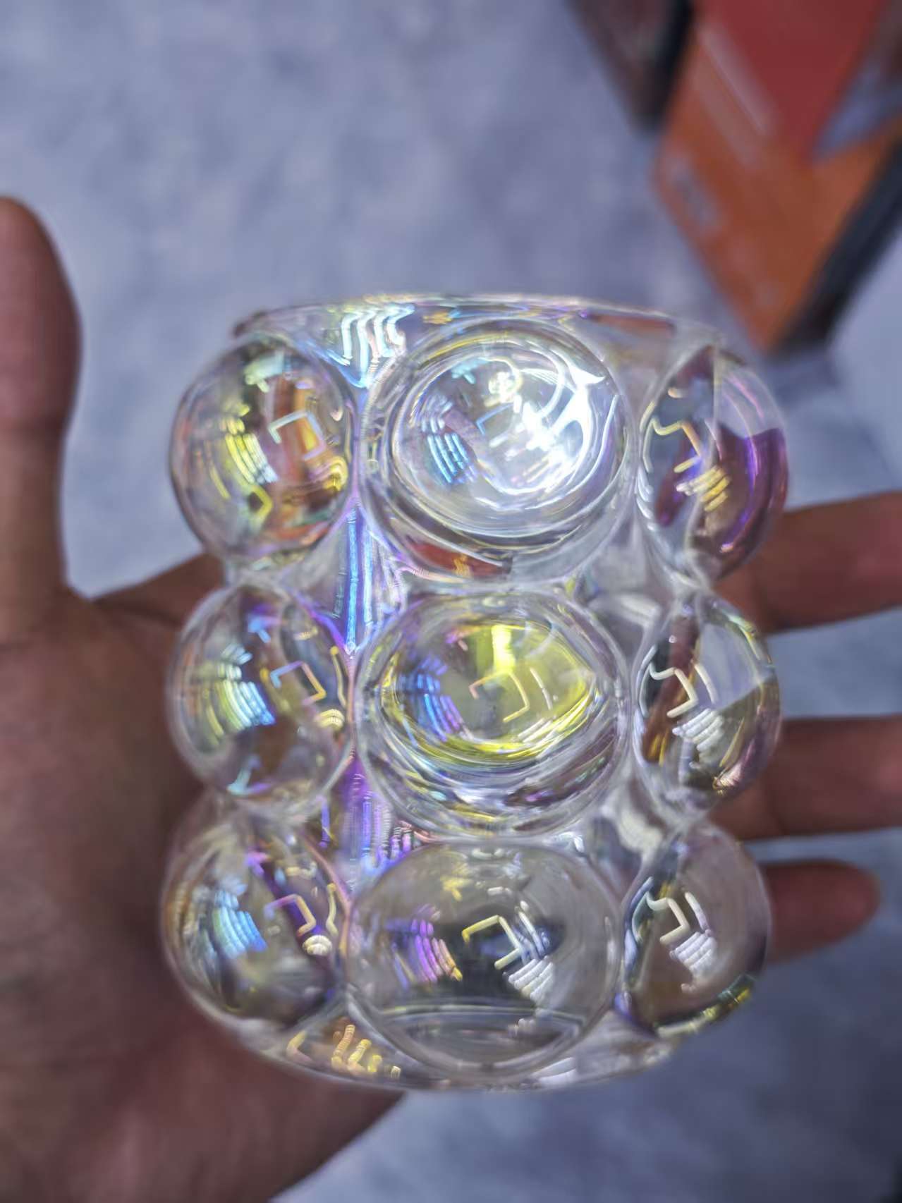 The transparent water cup is surrounded by colored glass balls