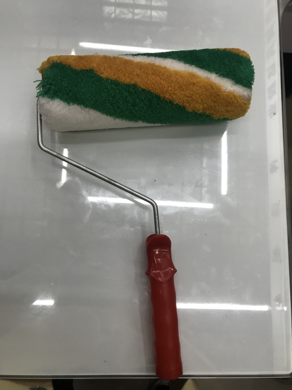 The green, yellow and white striped roller brush is a suitable tool for wall painting decoration
