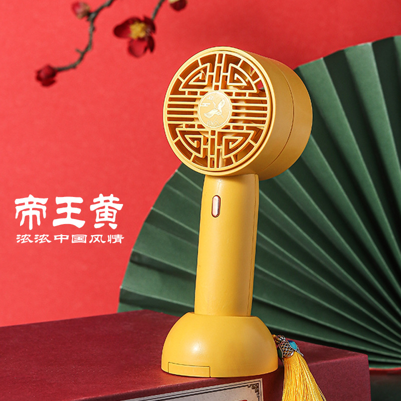 The compact and convenient foldable handheld charging mini fan with a national trend style is in imperial yellow