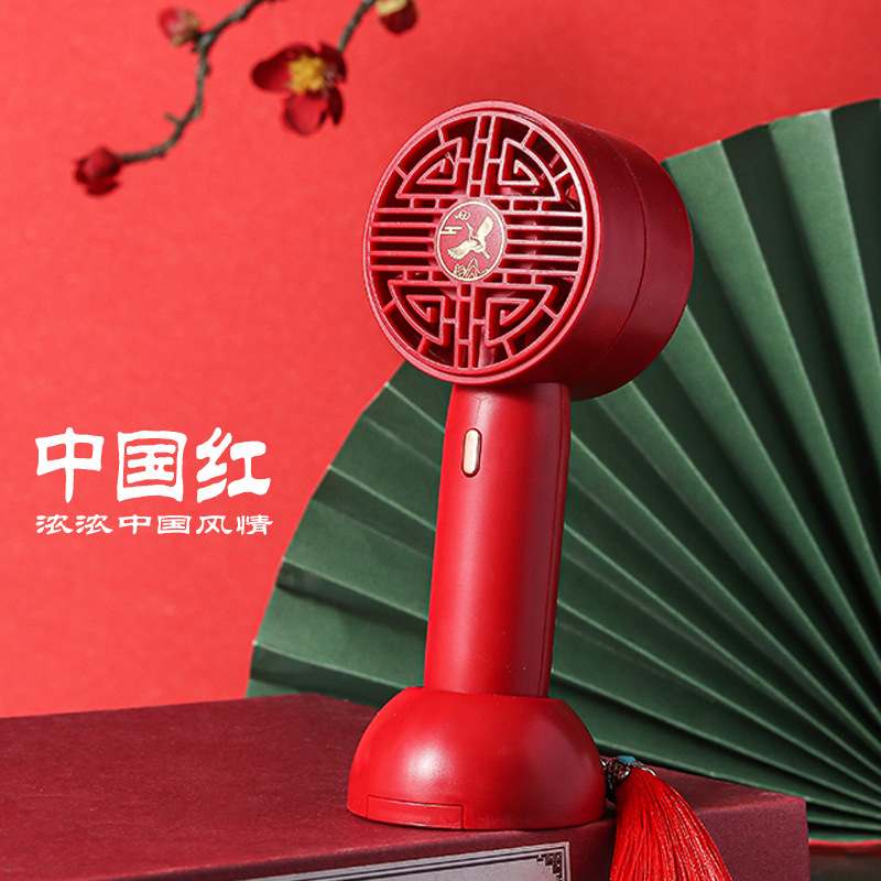 The small and convenient foldable handheld charging mini fan with a national trend style, in the red color of the Forbidden City