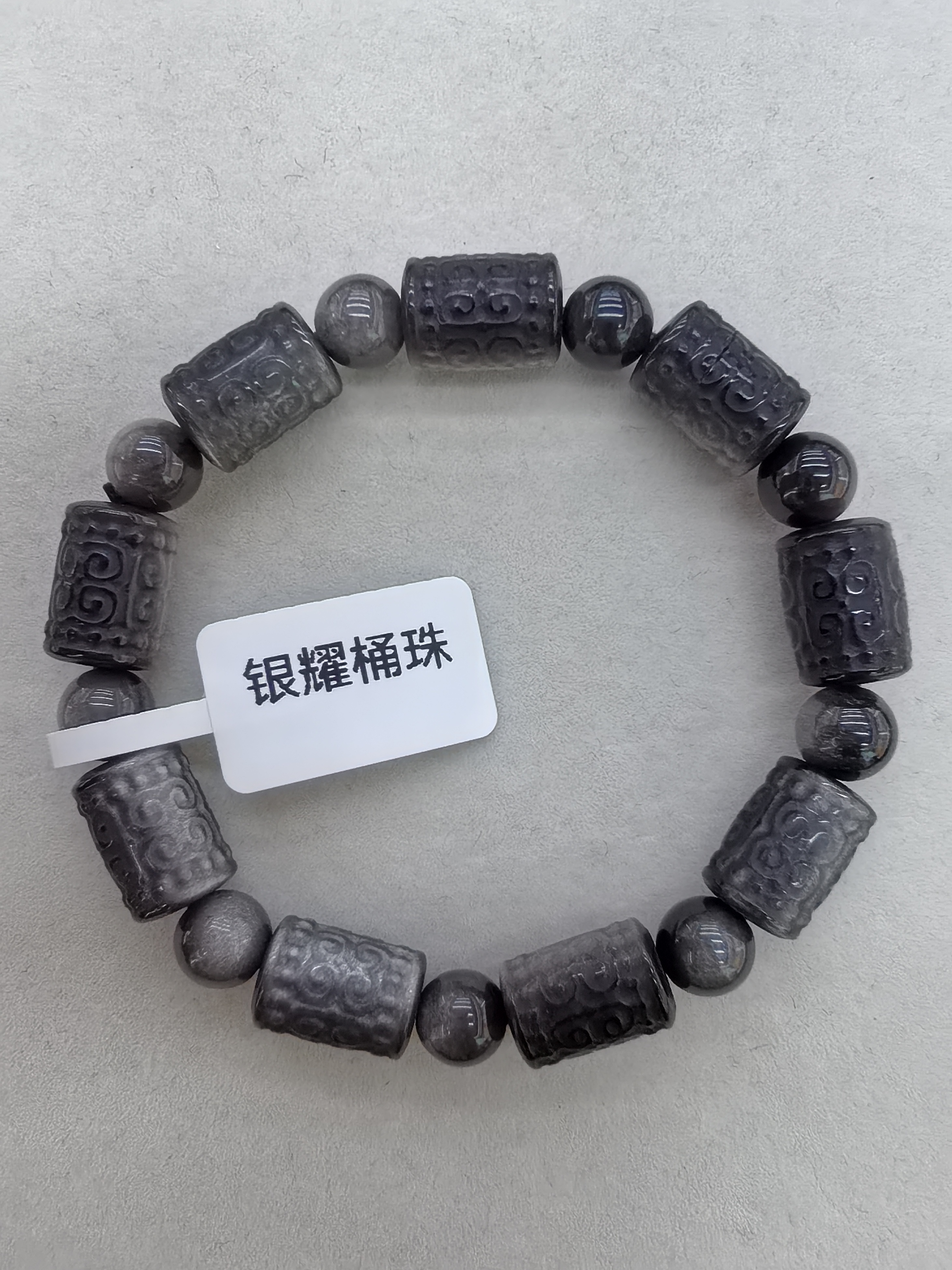 银耀桶珠是黑曜石的一种，属于天然玻璃。是由于火山熔岩迅速地冷却凝结形成。银耀石常见的颜色为银灰色、蓝色、绿色或紫色手串