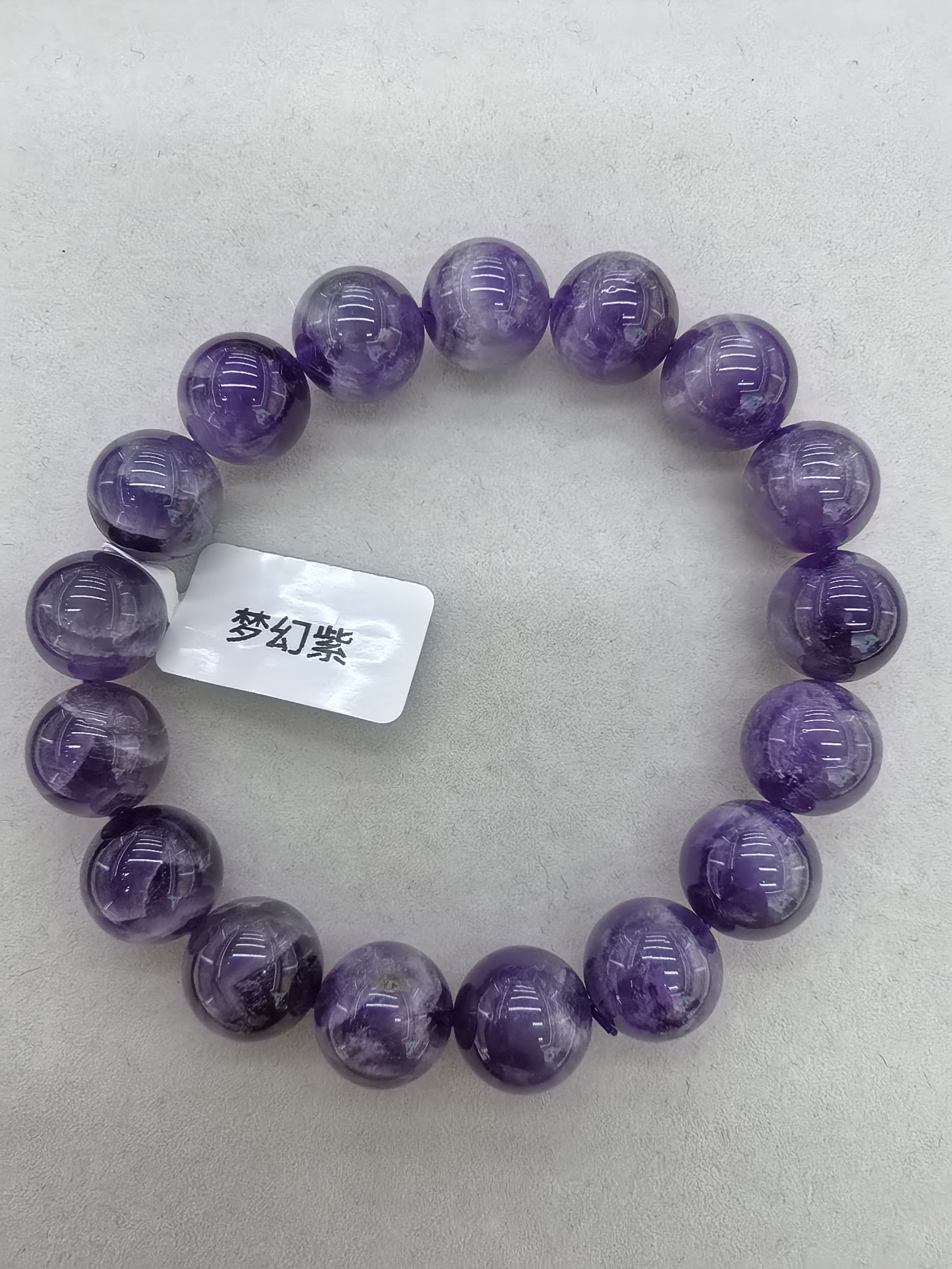 梦幻紫水晶之间会有紫白相间的纹路，带有石性，基本上不透。表面有波浪纹，紫色和白色逐渐交替，晶体通透度较低手串