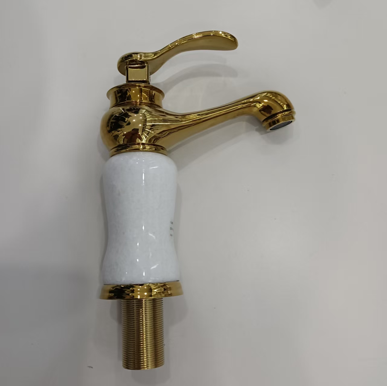 A golden retro faucet with a white ceramic base, suitable for both cold and hot water in kitchens, bathrooms and hotels details Picture