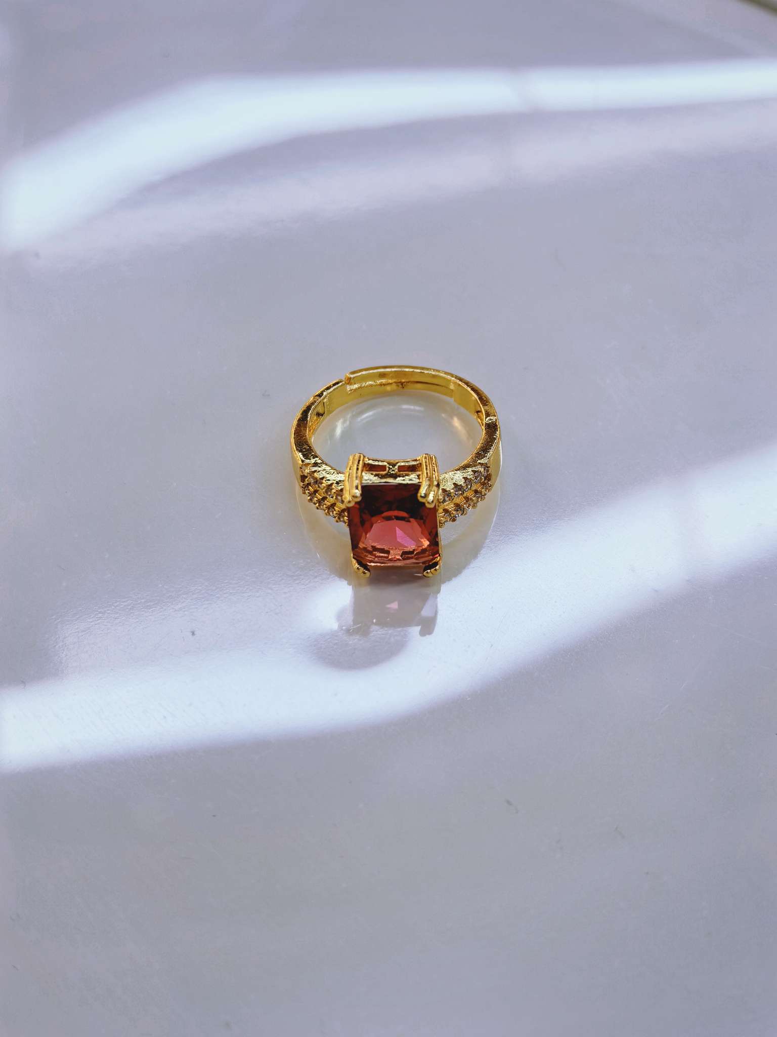 A simple and fashionable ladies' accessory with a golden ring and red square gemstones