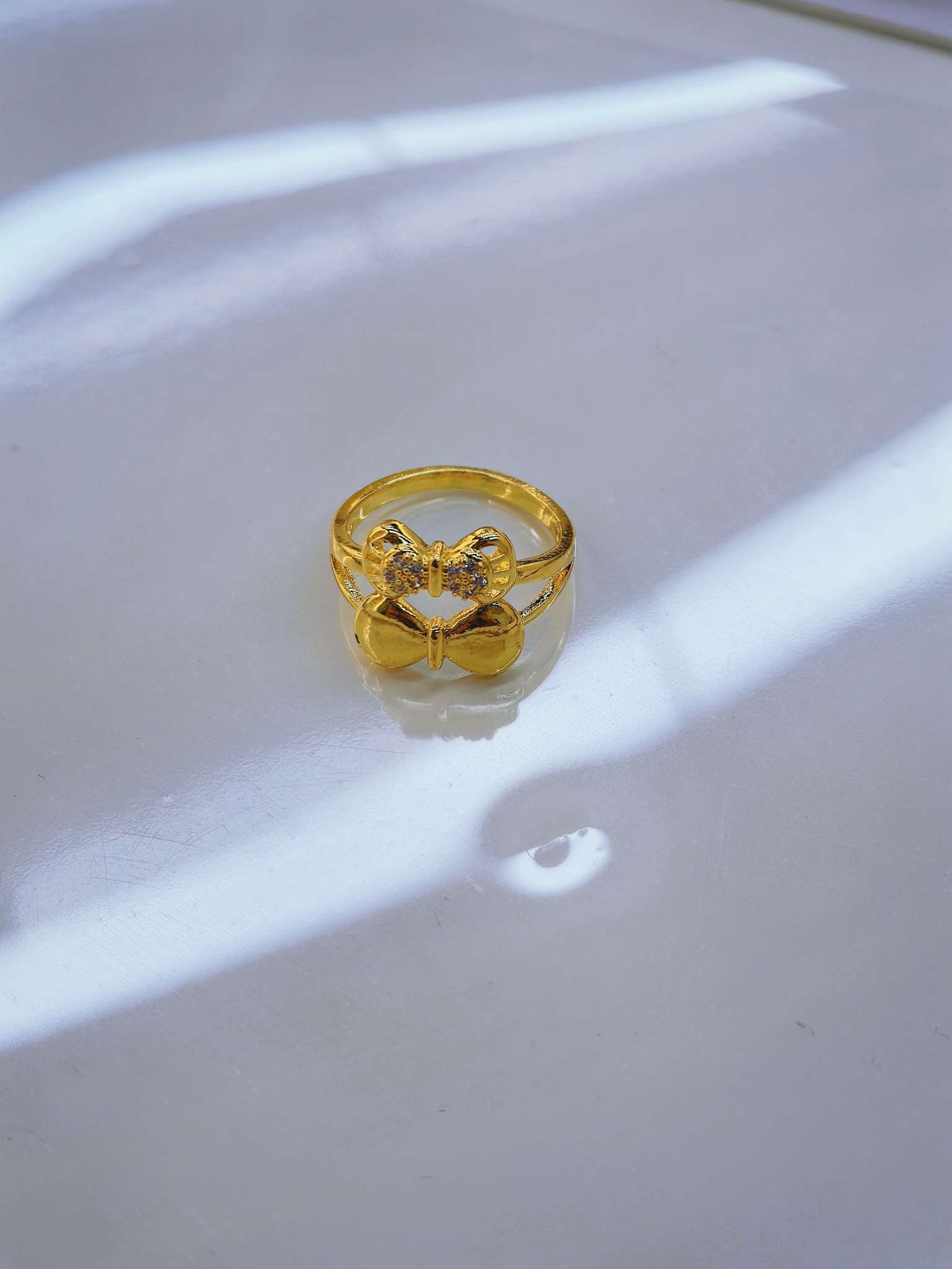 A golden bow-shaped ring is a fashionable and simple ladies' accessory