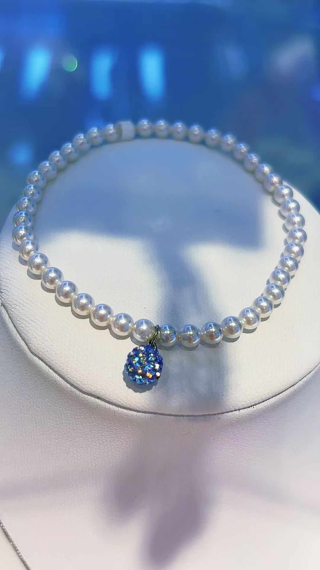 A custom-made irregular and versatile snake-shaped bracelet for women with a white pearl bracelet and a blue crystal ball pendant details Picture
