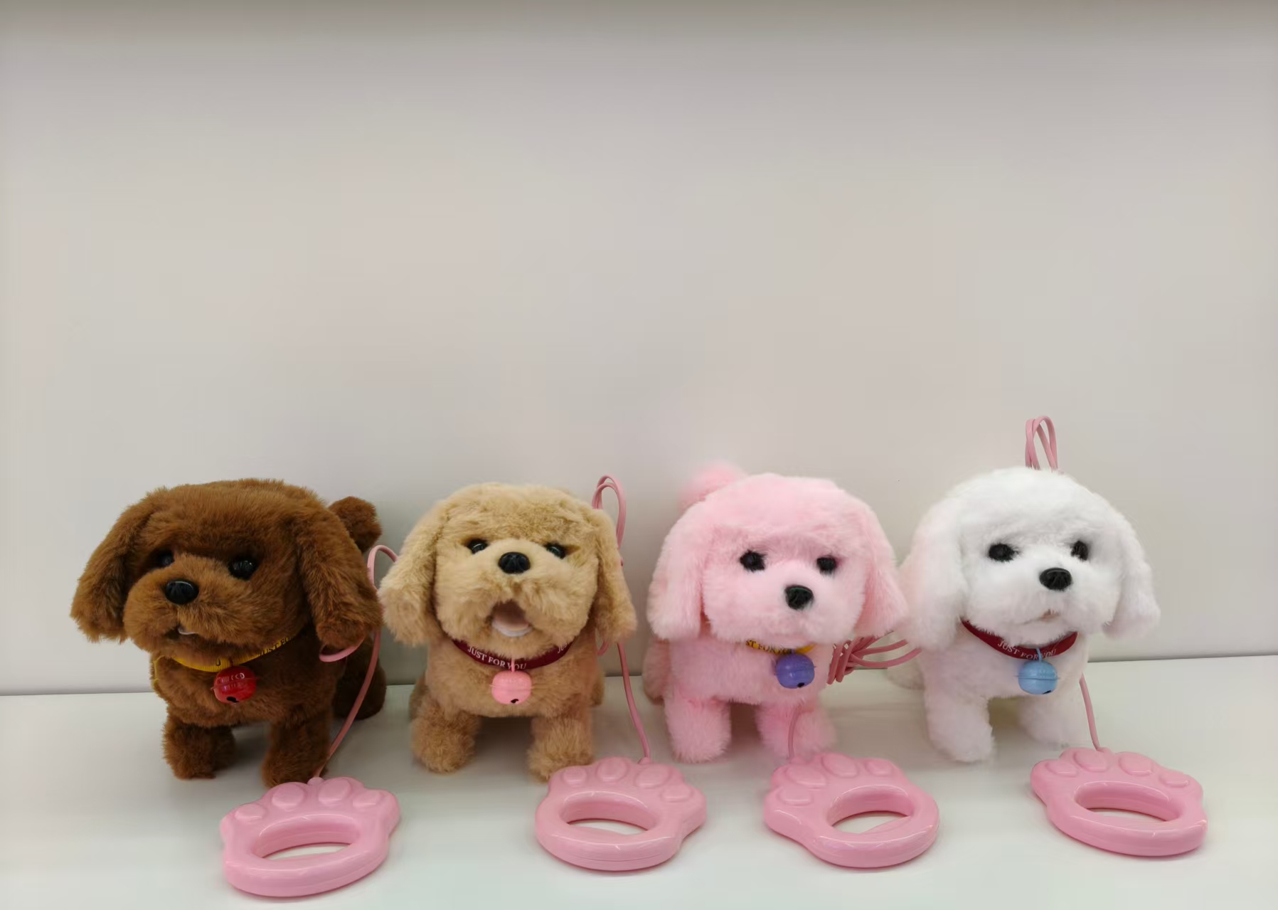 Four plush puppy toys, brown, light brown, pink and white with collars, bells, pink claw-shaped leash, pet toys