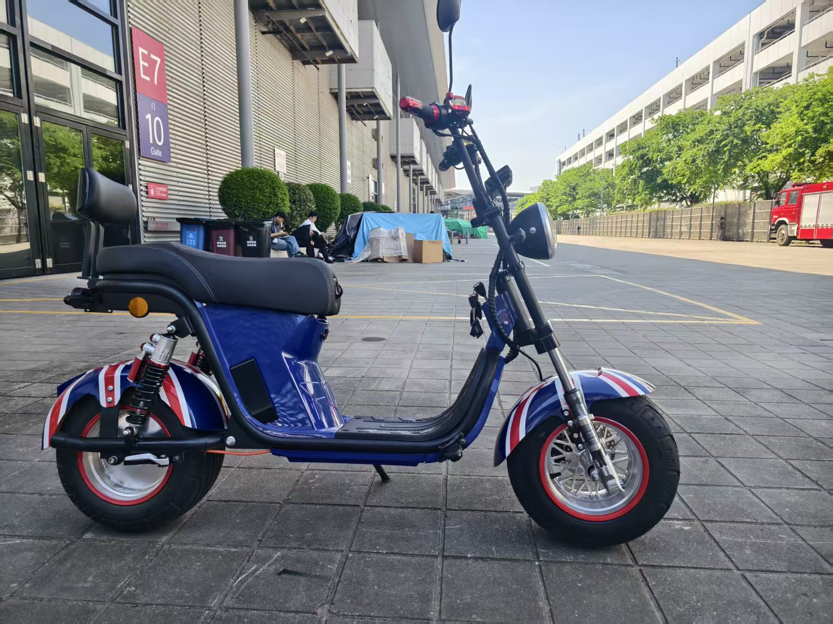 The electric vehicle features a blue British flag pattern, black seats, footrests, red handles, clear headlights and rearview mirrors Application Scenario