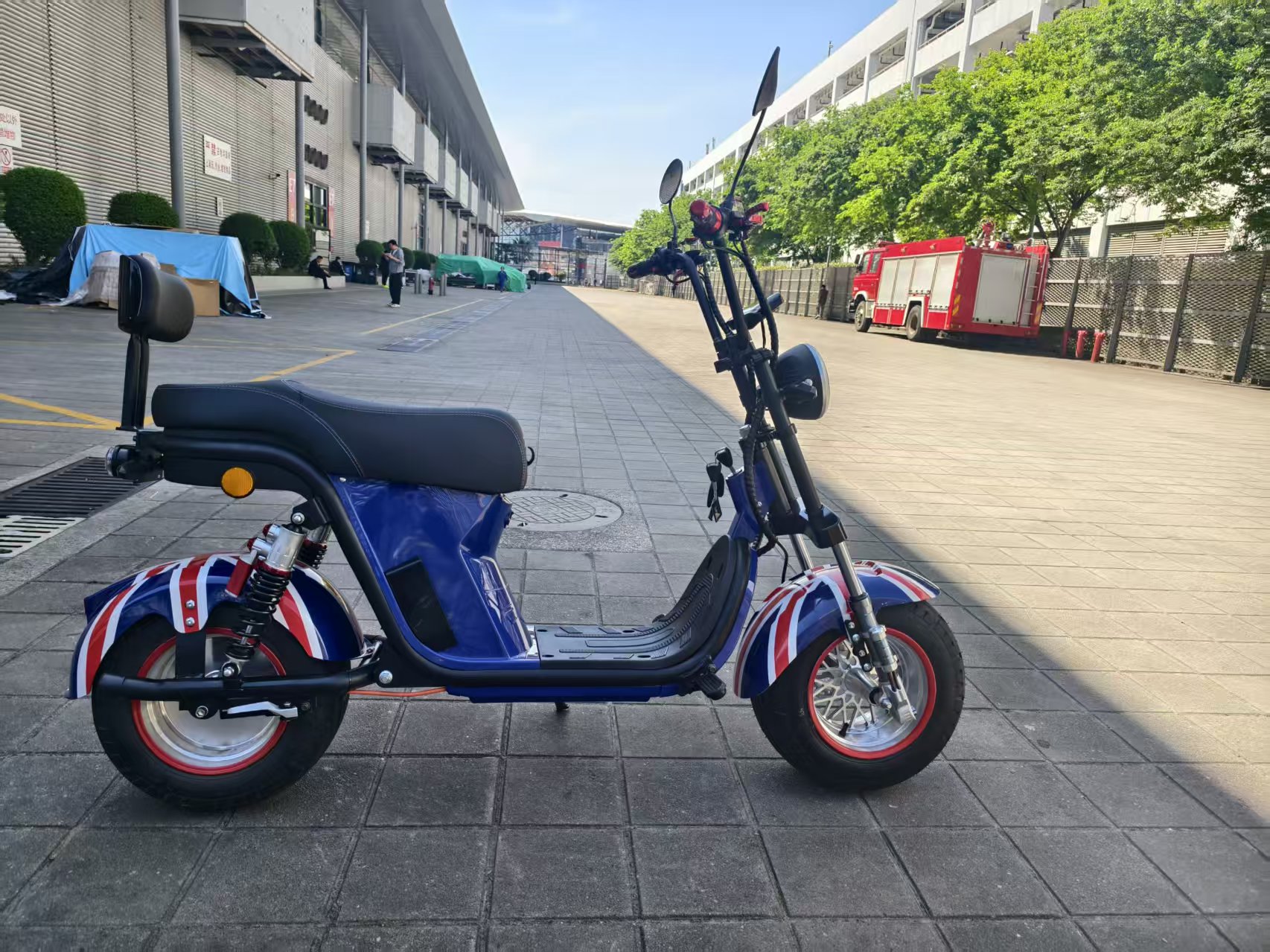 The electric vehicle features a blue British flag pattern, black seats, footrests, red handles, clear headlights and rearview mirrors Item Picture