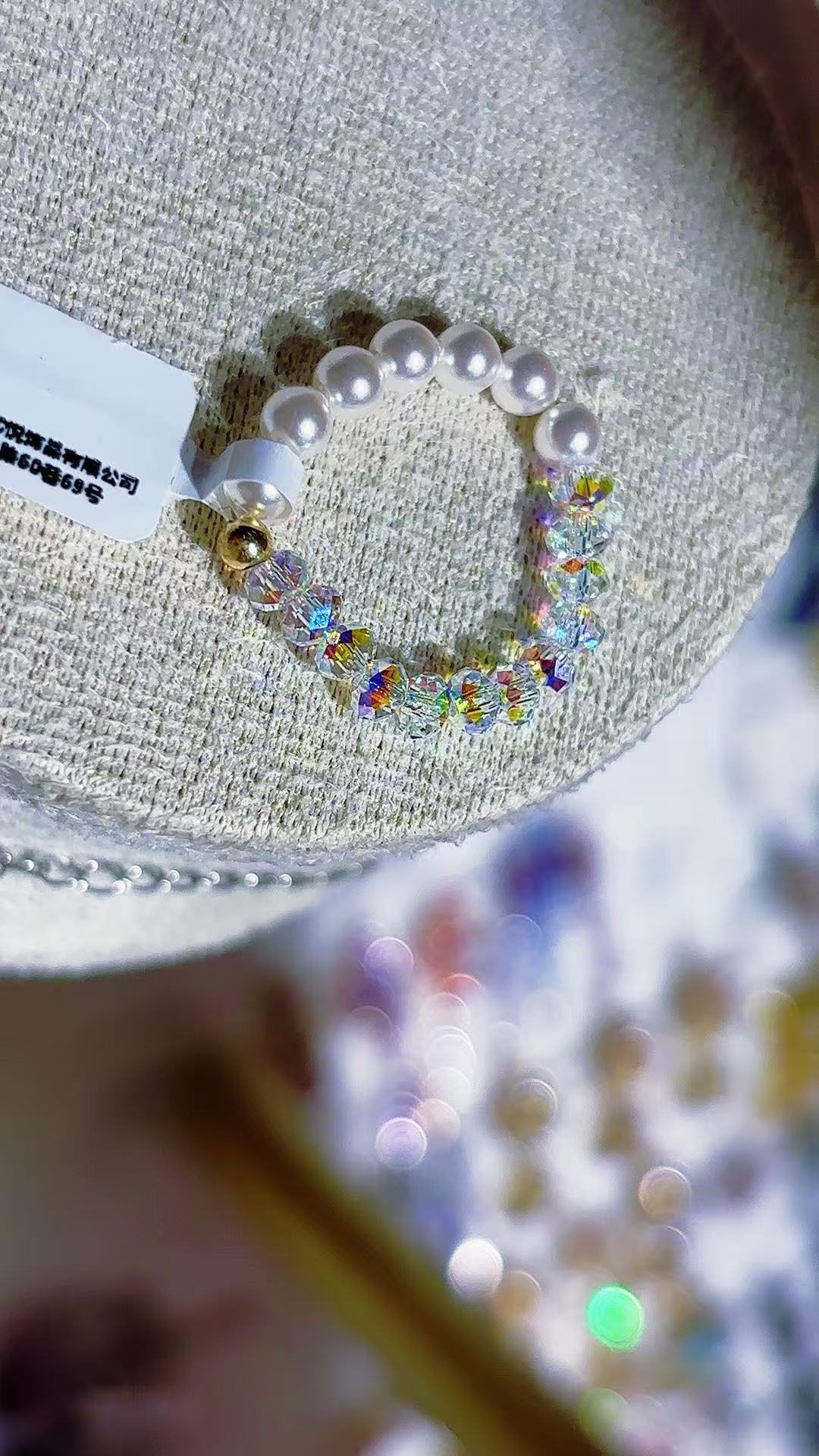 A white beaded bracelet inlaid with rainbow crystals and pearls, a titanium steel bracelet for men