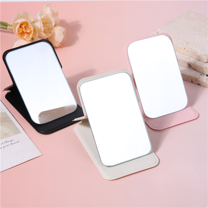 A portable small mirror for women, a simple desktop that can stand upright, ultra-mini student portable women's dressing and folding touch-up mirror Application Scenario
