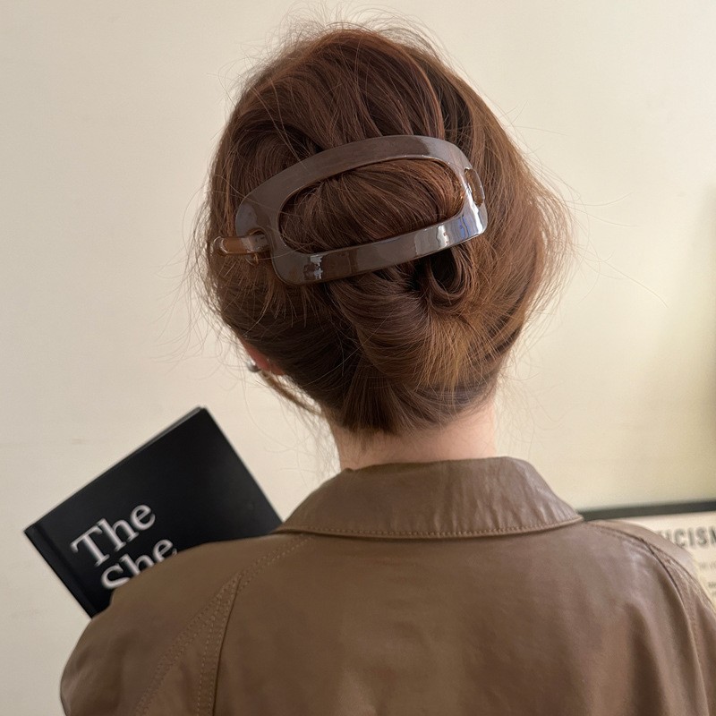 The simple and elegant oval hair clip at the back of the female head exudes a sense of sophistication. The one-piece twist clip is a large bun with a generous amount of hair and a headwear clip details Picture