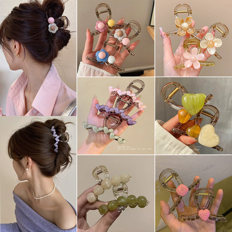 The sweet and heart-shaped flower hairpin is a medium-sized, transparent grey claw clip at the back of the female head, exuding a sense of elegance and sophistication. It is a shark clip headpiece full image