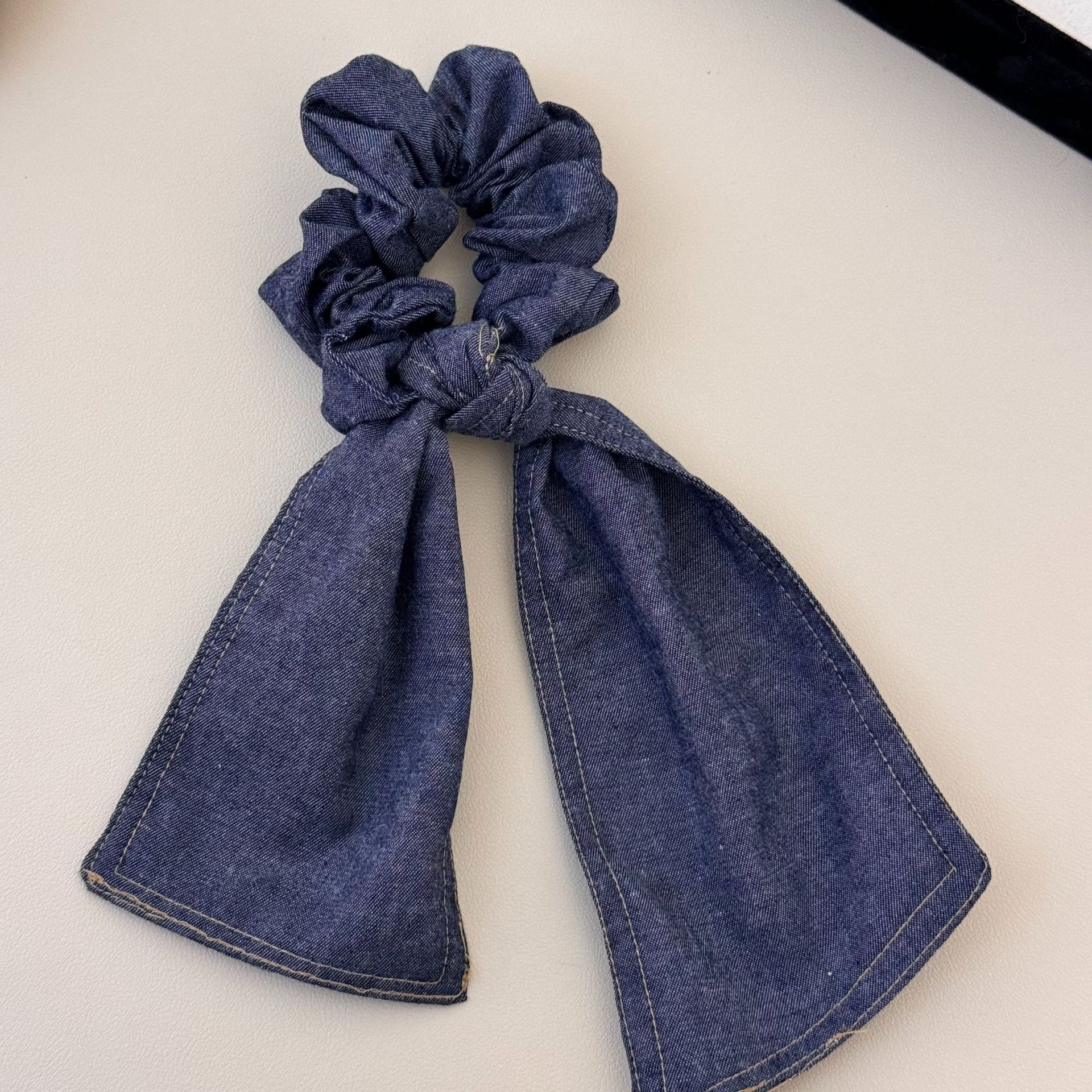 A versatile and laid-back large denim ribbon bow hair band with a high-end and elegant style. It can be used as a hair tie and bun accessory for women undefined
