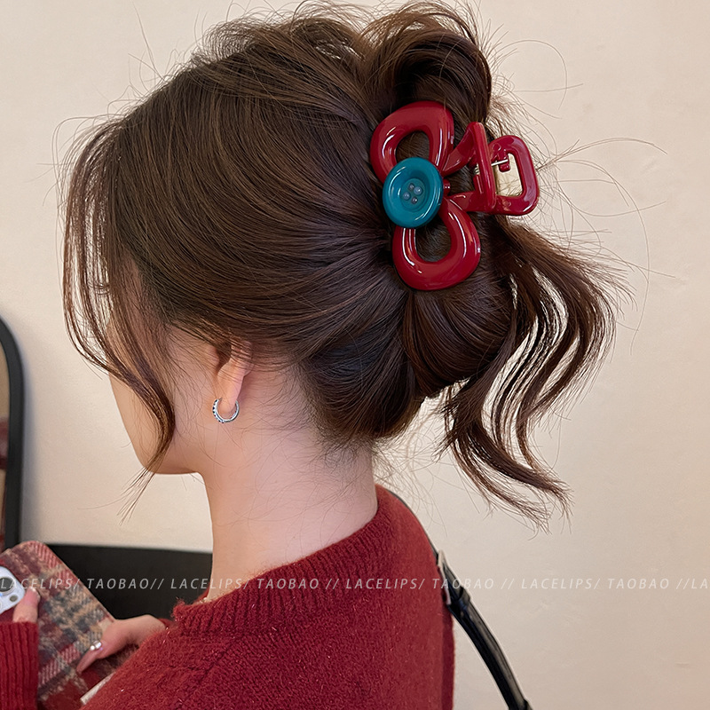 Retro red bow button grabber with a high-end and niche design. The contrasting color shark clip is a fashionable and versatile hair accessory full image
