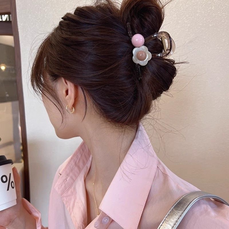 The sweet and heart-shaped flower hairpin is a medium-sized, transparent grey claw clip at the back of the female head, exuding a sense of elegance and sophistication. It is a shark clip headpiece details Picture