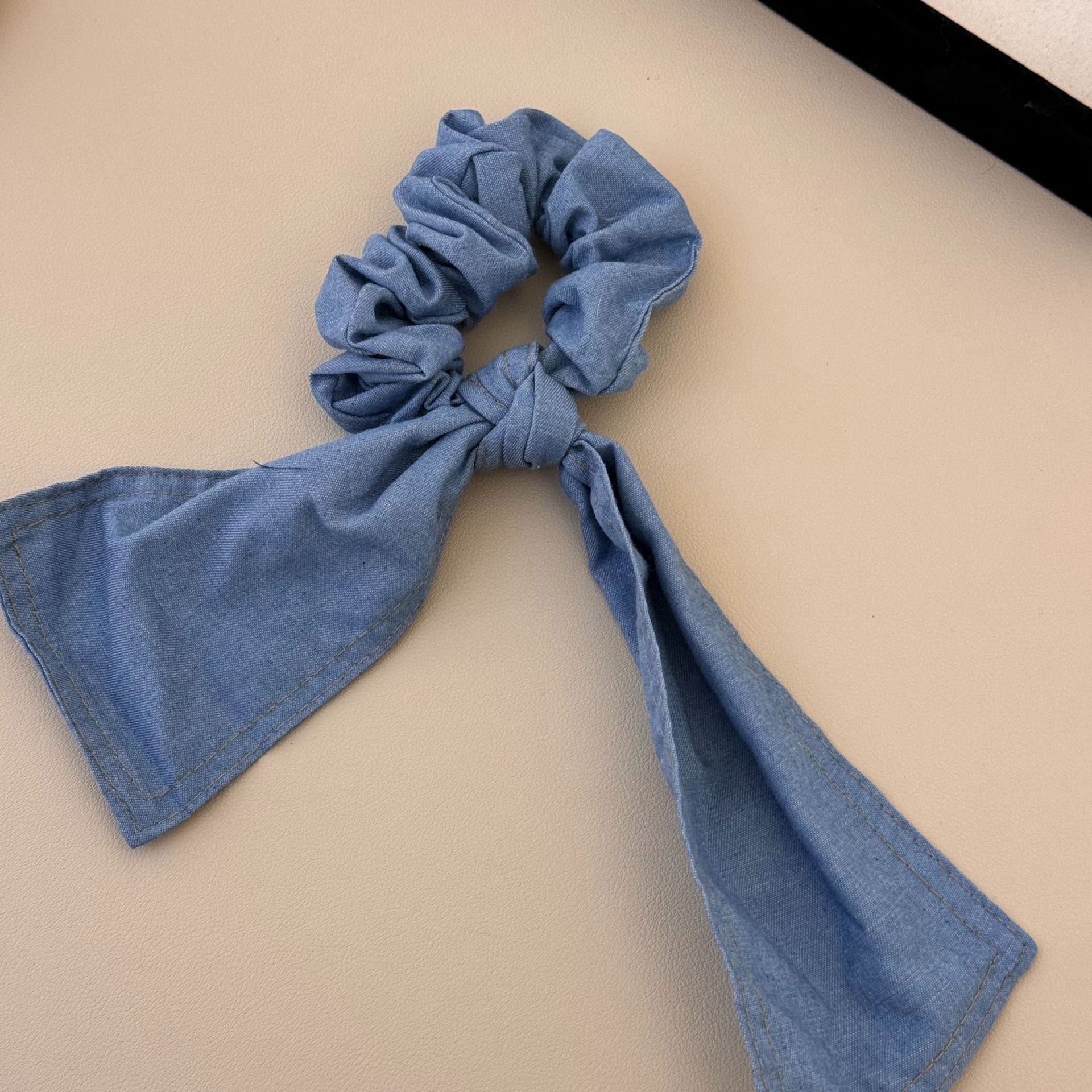 A versatile and laid-back large denim ribbon bow hair band with a high-end and elegant style. It can be used as a hair tie and bun accessory for women undefined