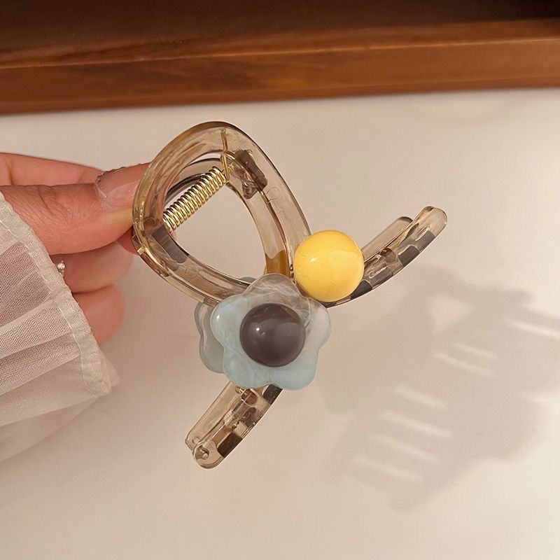 The sweet and heart-shaped flower hairpin is a medium-sized, transparent grey claw clip at the back of the female head, exuding a sense of elegance and sophistication. It is a shark clip headpiece undefined