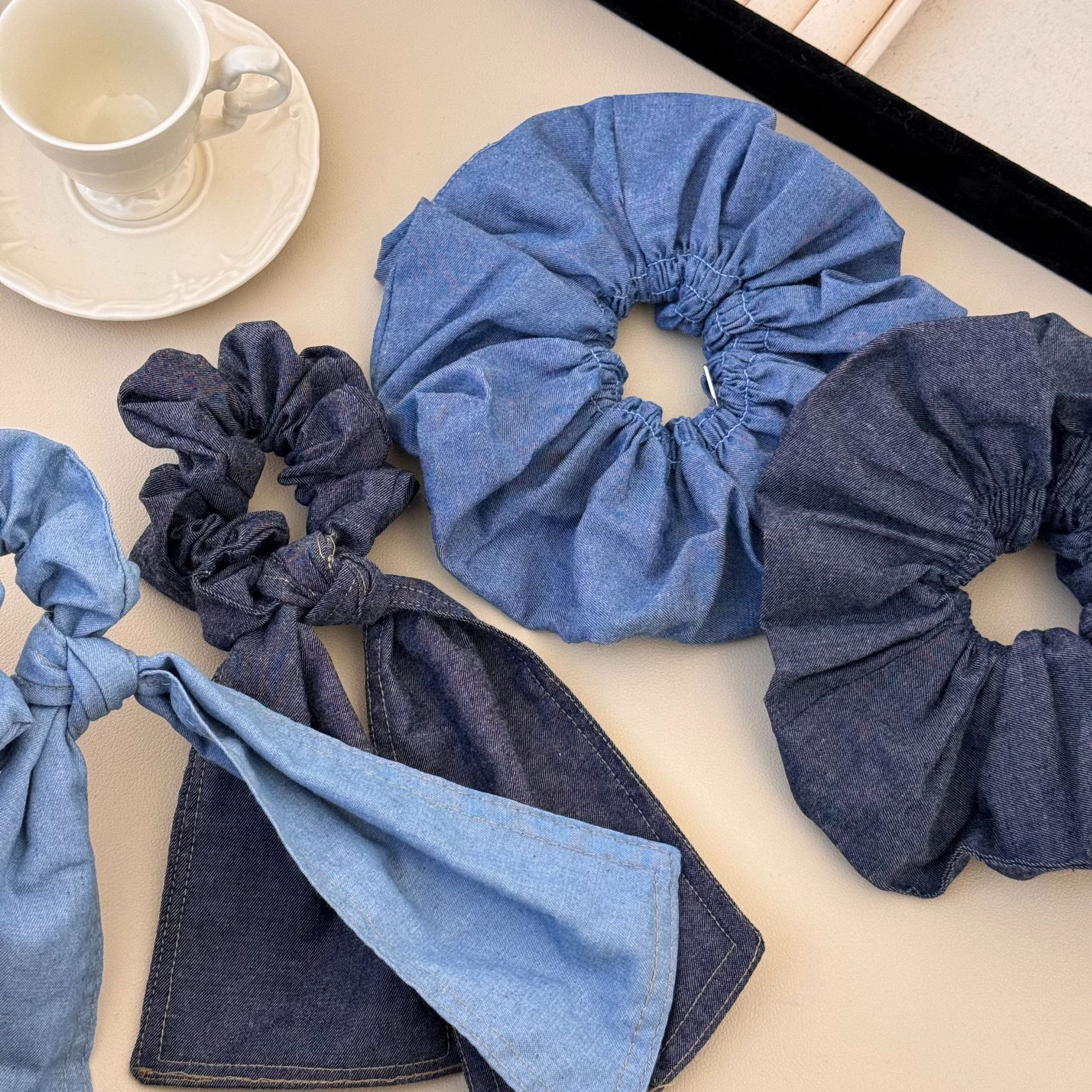 A versatile and laid-back large denim ribbon bow hair band with a high-end and elegant style. It can be used as a hair tie and bun accessory for women