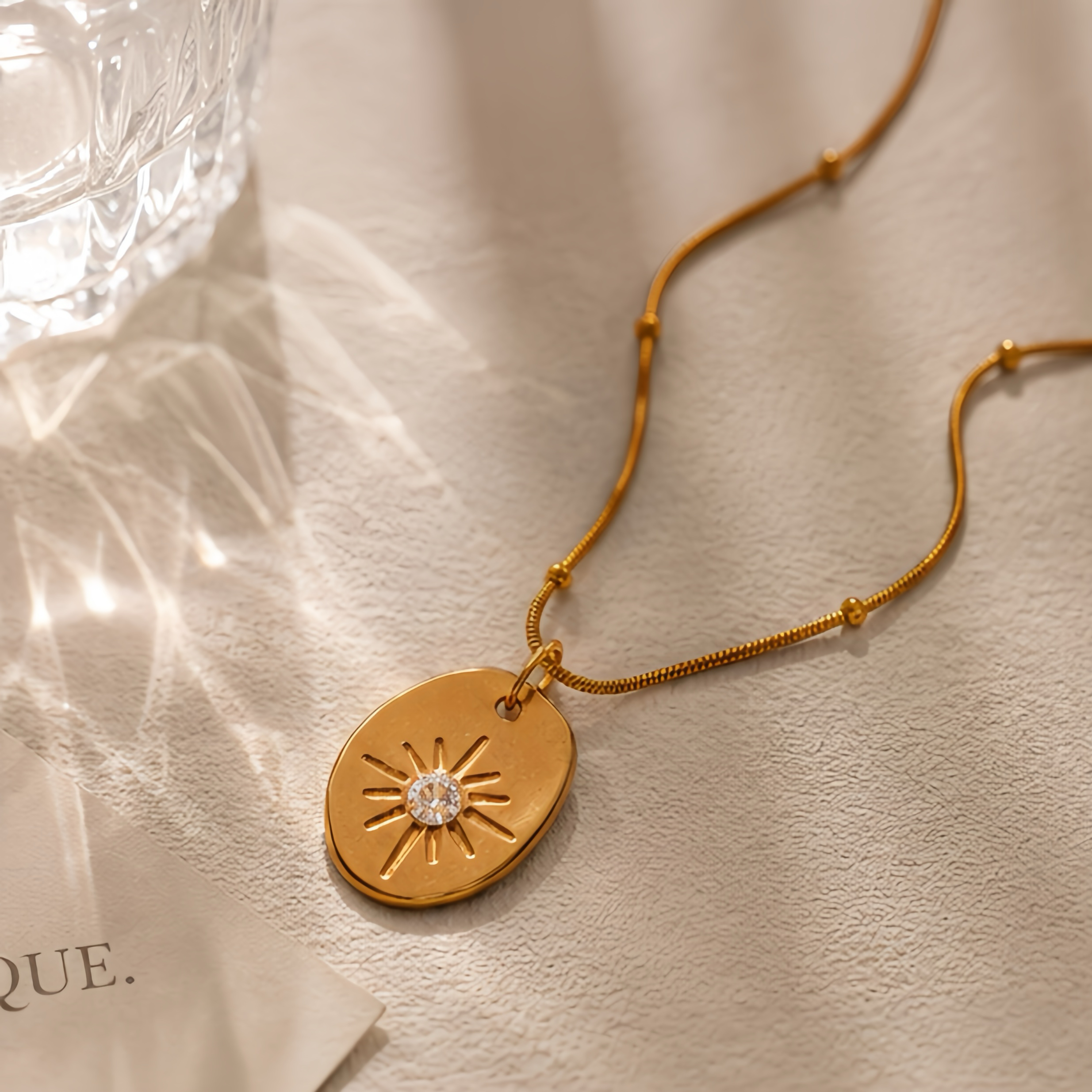 Irregular oval embossed sun pattern pendant, stainless steel snake bone chain, light luxury commuting outfit, simple Korean style, high-end collarbone neck accessory Specification image