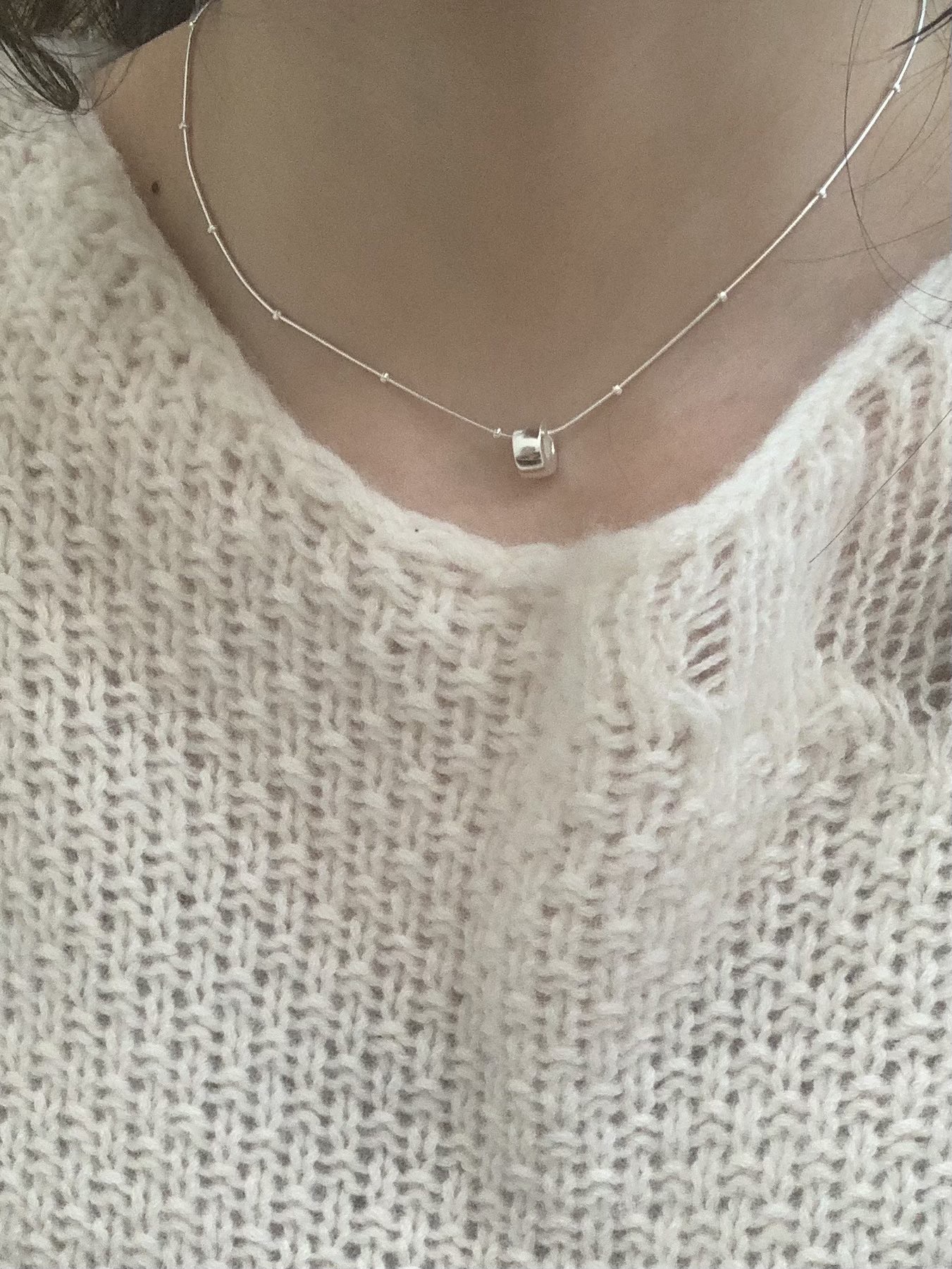 The S925 sterling silver necklace features a simple silver bead, embellishing the neck
