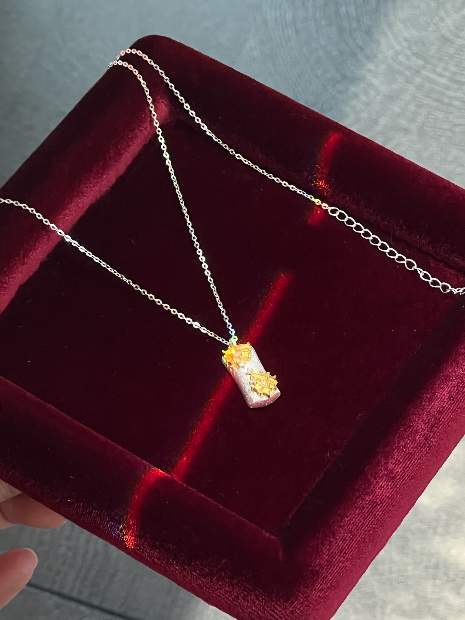 The S925 sterling silver necklace has a silver base and gold flowers