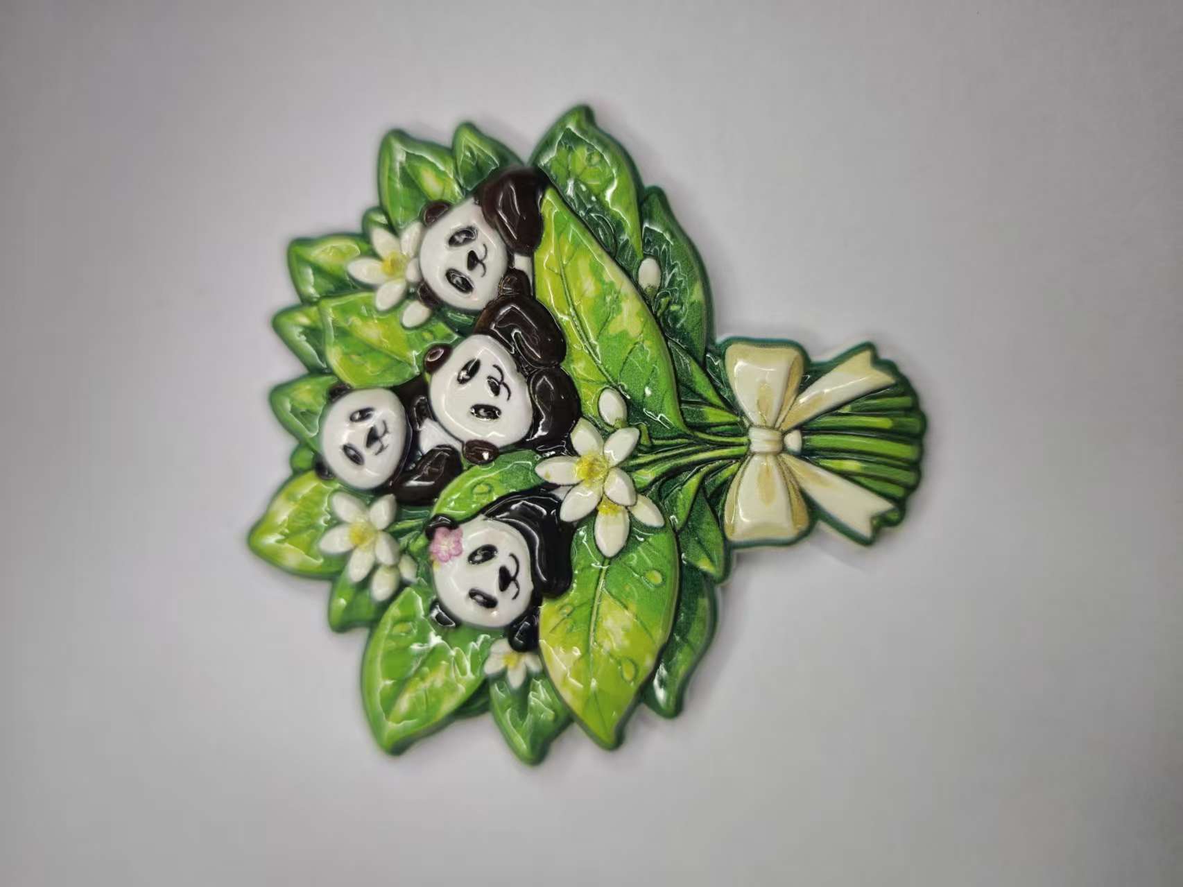 Three panda-shaped fridge magnets in the green leaf cluster of national trend