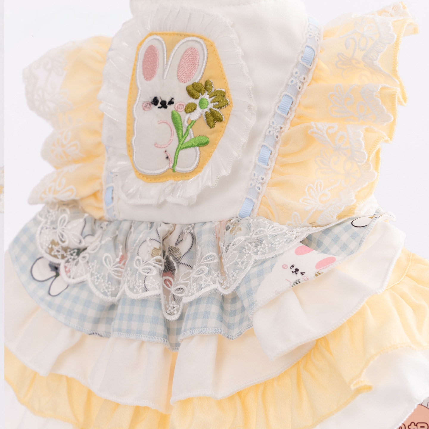 A yellow and white contrasting pet dress with cartoon patchwork embroidery and multi-layered lotus leaf lace, creating an atmosphere for daily photos Application Scenario