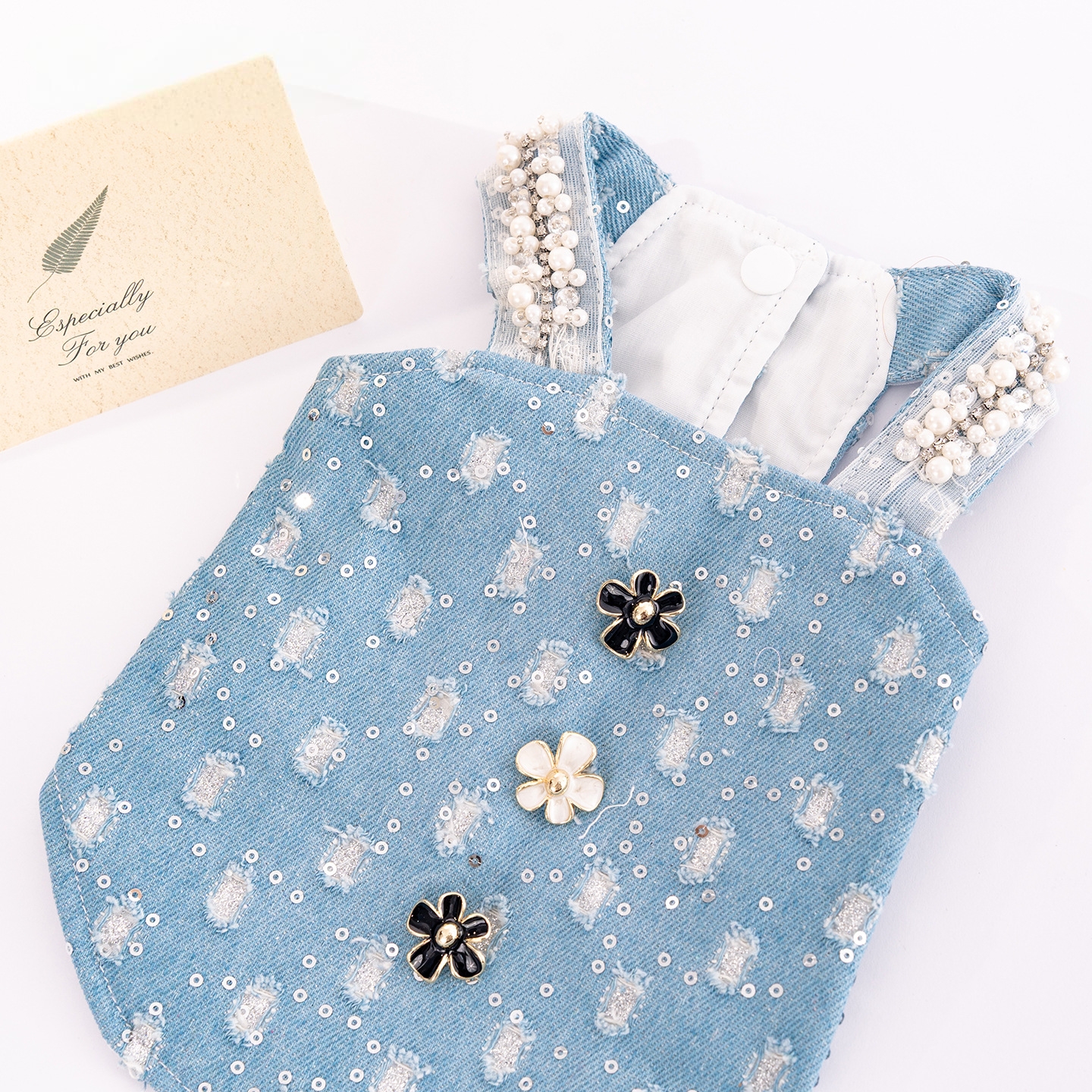 Heavy industry pearl shoulder strap denim pet vest with sequined jacquard flower buttons creates an atmosphere. The pet outing top can be paired with a beret Specification image