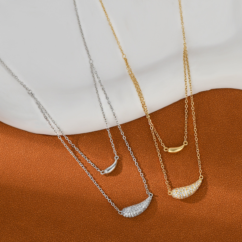 A golden double-layer curved pendant necklace with a unique design for women. It features a stacked collarbone chain and is a versatile necklace for daily commuting