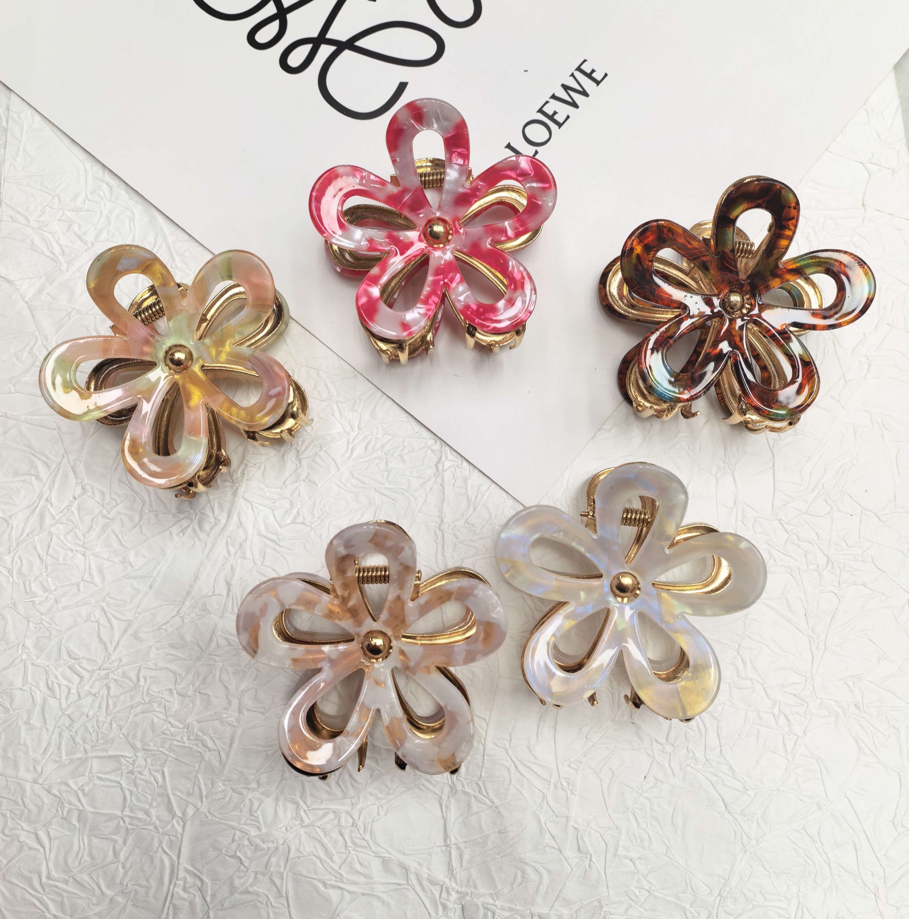 The new Korean version of the flower-shaped hollowed-out grab clip for women is a versatile hairpin for the back of the head, exuding a high-end and elegant charm. It is a shark clip hair accessory