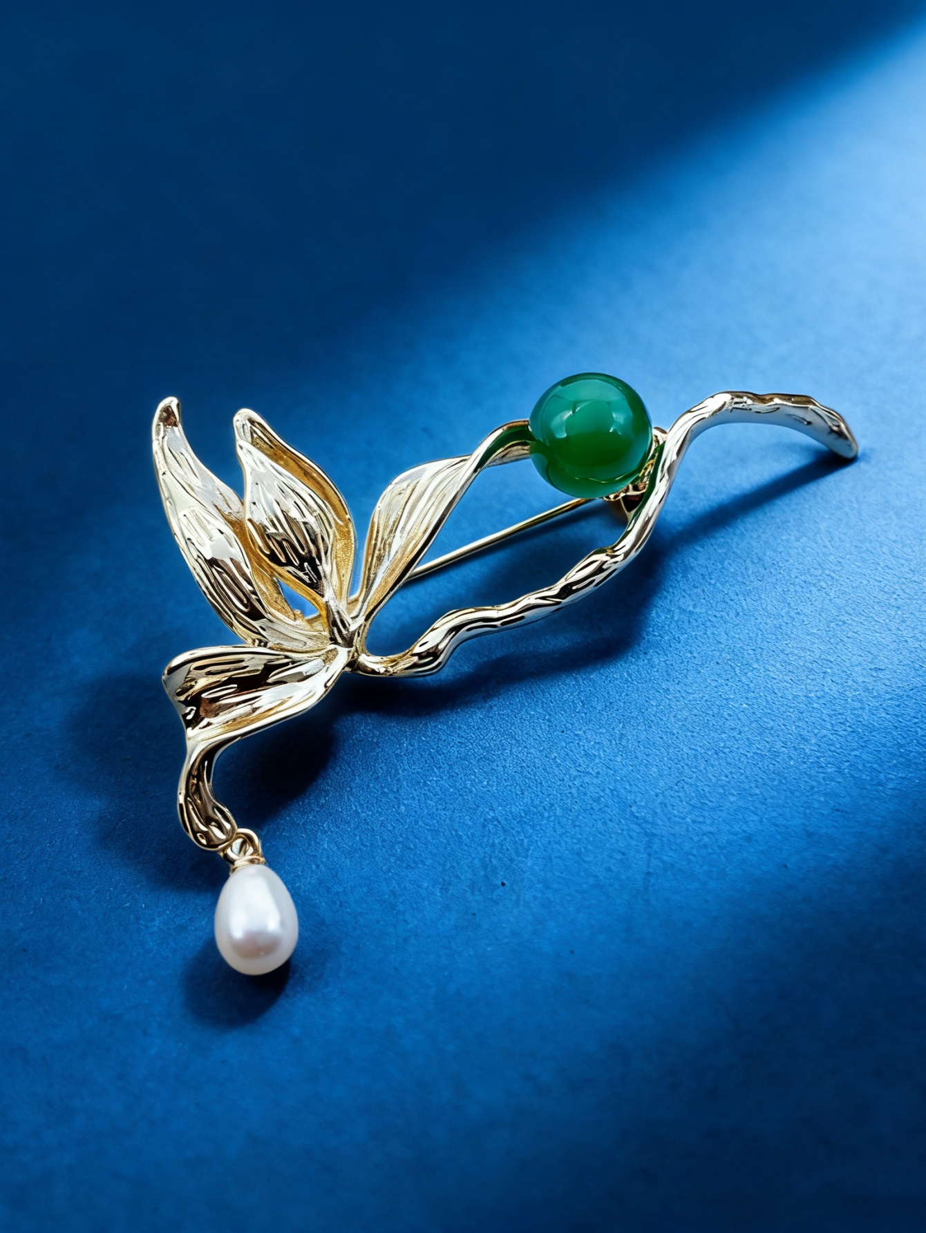 A golden leaf-shaped brooch set with green round beads, white pearls and a fashionable pin in a blue velvet box Item Picture