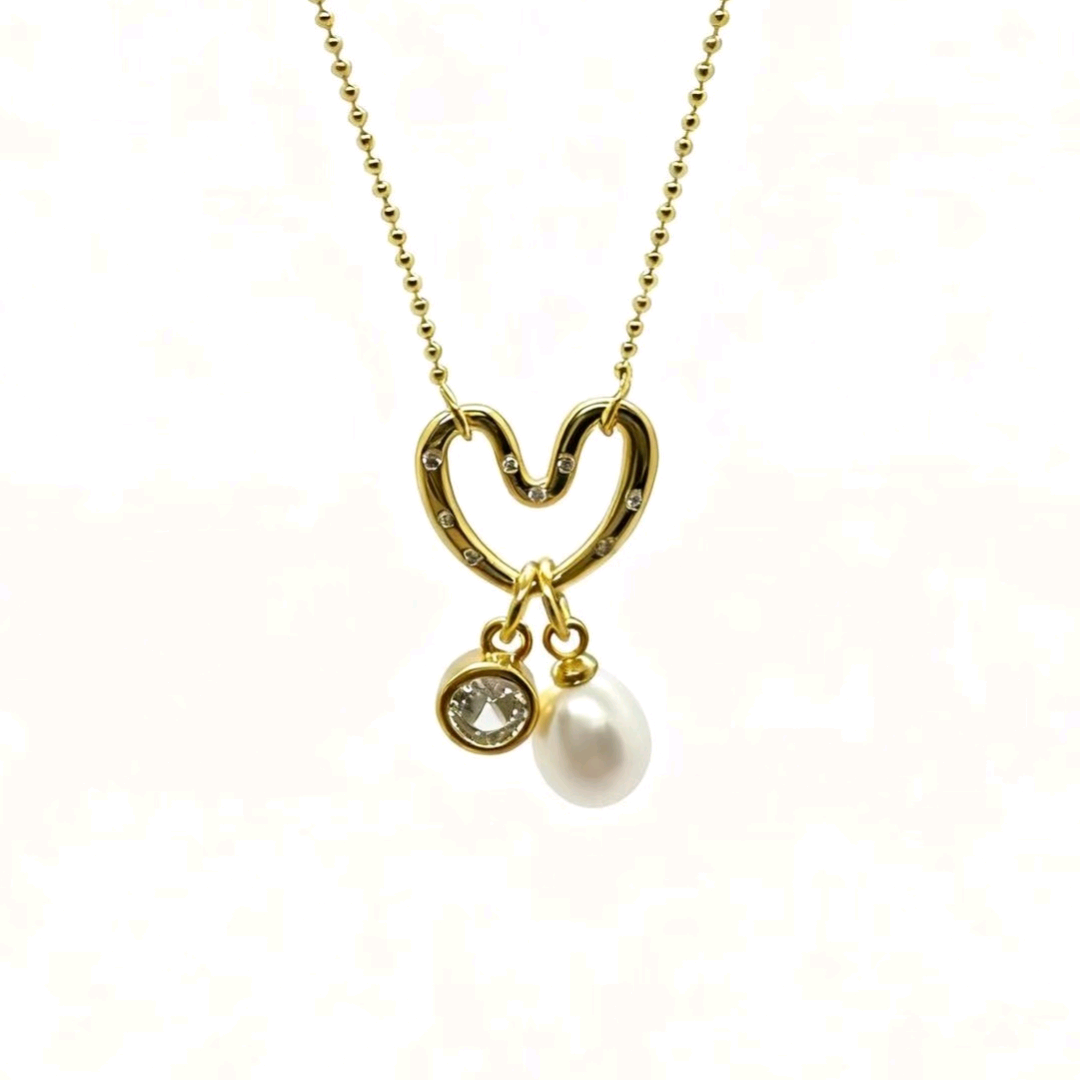 A gold-plated necklace with diamonds, pearls, hearts and copper gold-plated ornaments