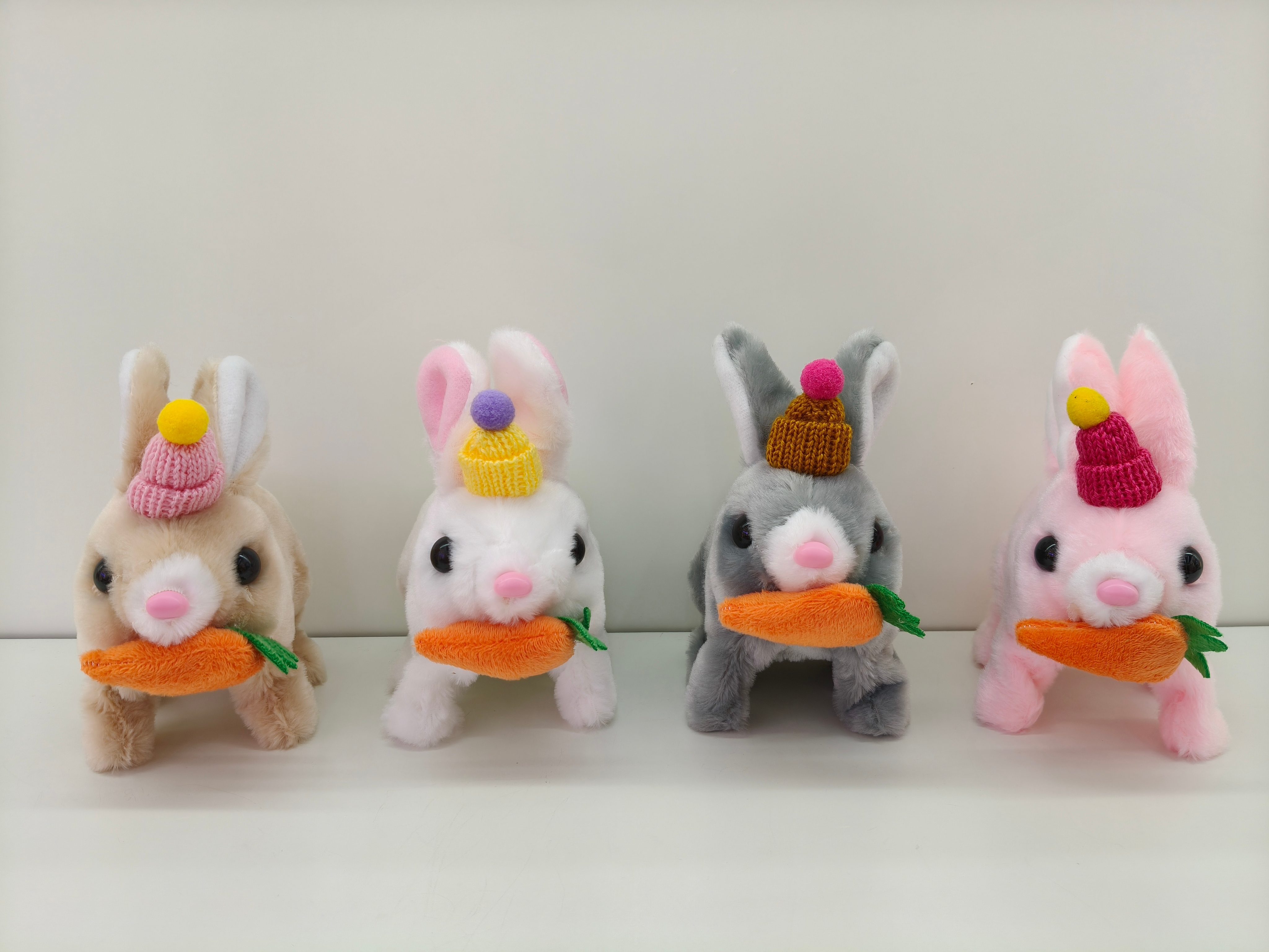 Four hat radish rabbits wearing hats and carrying carrots can walk and make sounds. They are cute toys