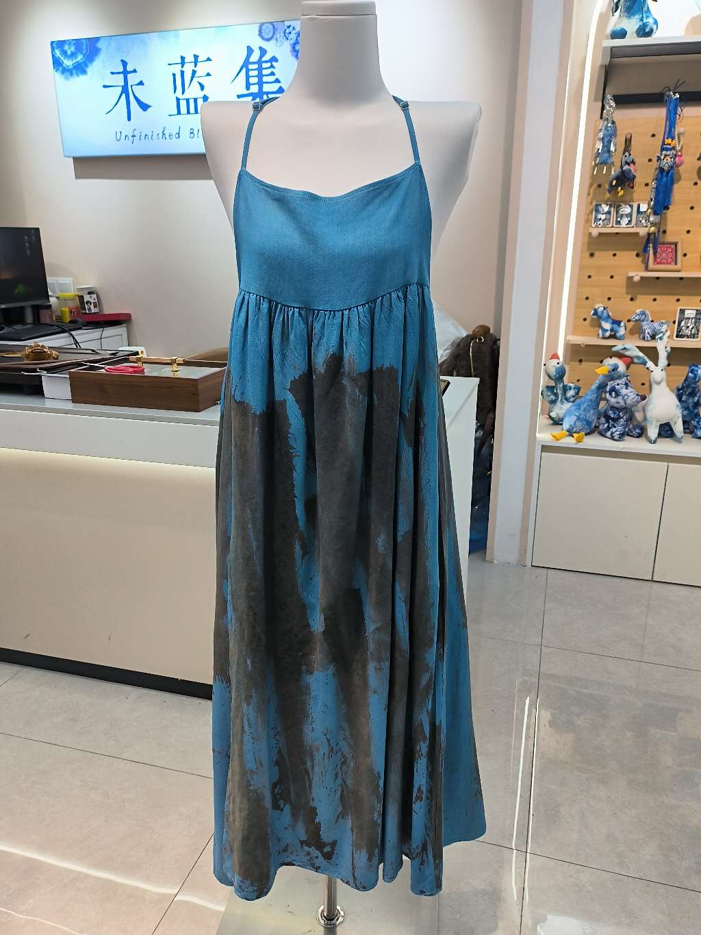 The blue tie-dyed long dress is sexy and beautiful. The backless halter dress is worn over a trendy and fashionable silicone outfit