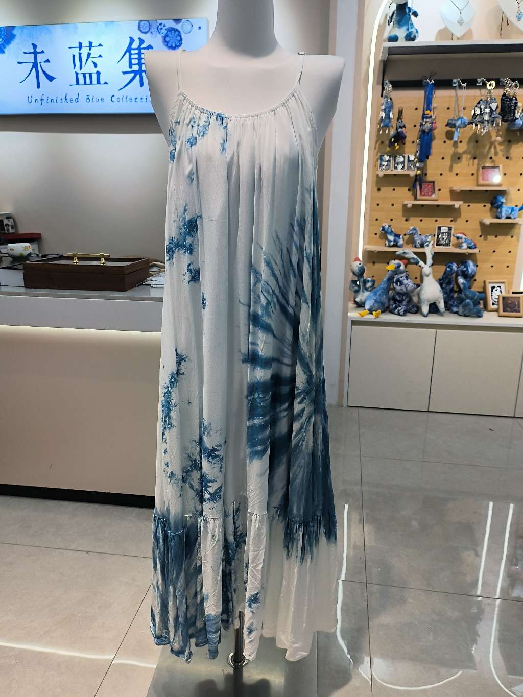 A blue and white tie-dyed long dress with a halter top, paired with a short-sleeved off-the-shoulder top, a fashionable and versatile silicone accessory
